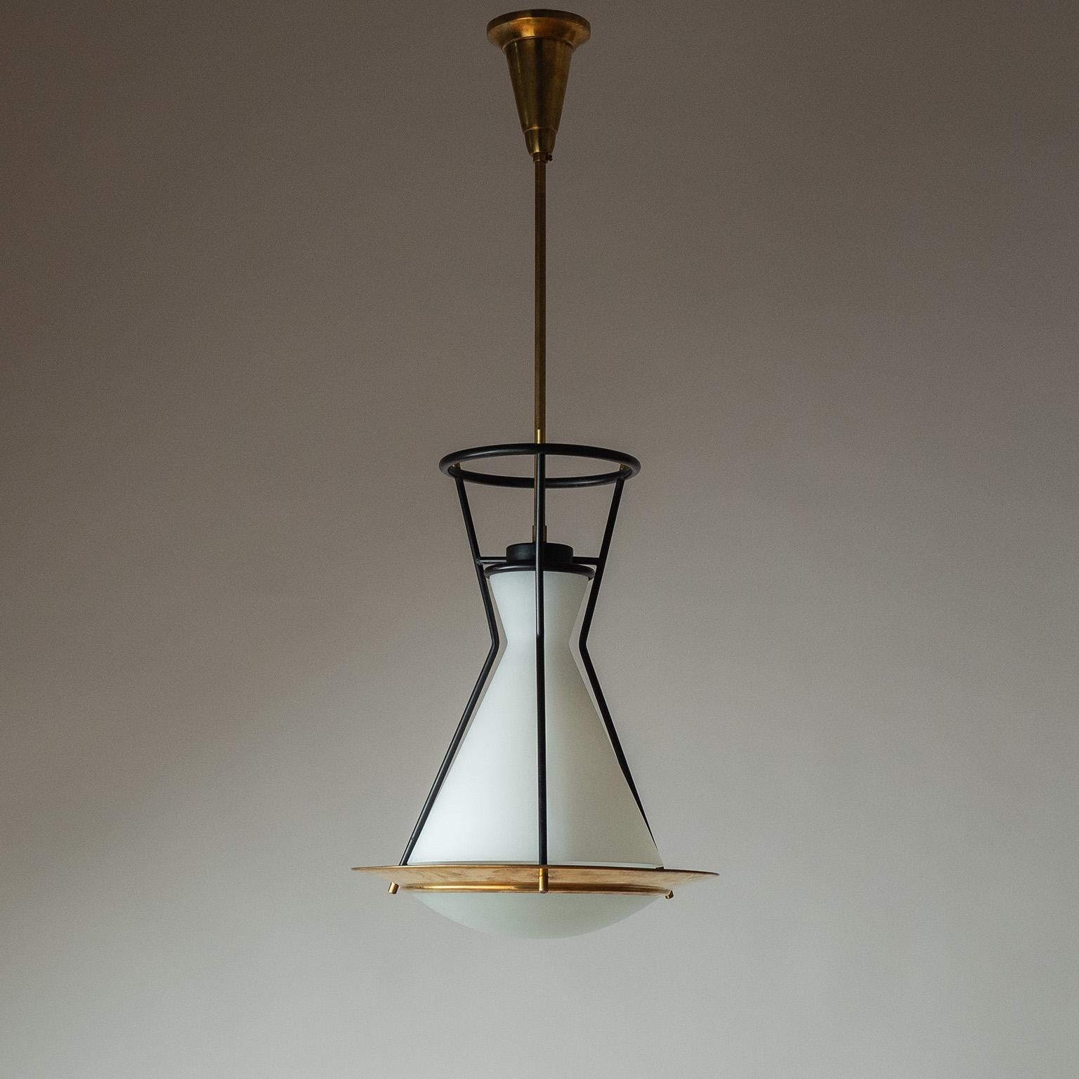 Modernist Italian pendant from the 1950s, attributed to Bruno Chiarini. Geometric brass and lacquered steel frame with a large conical satin glass diffuser. Attached underneath is a large brass frame with a curved and textured glass disc. Heavy