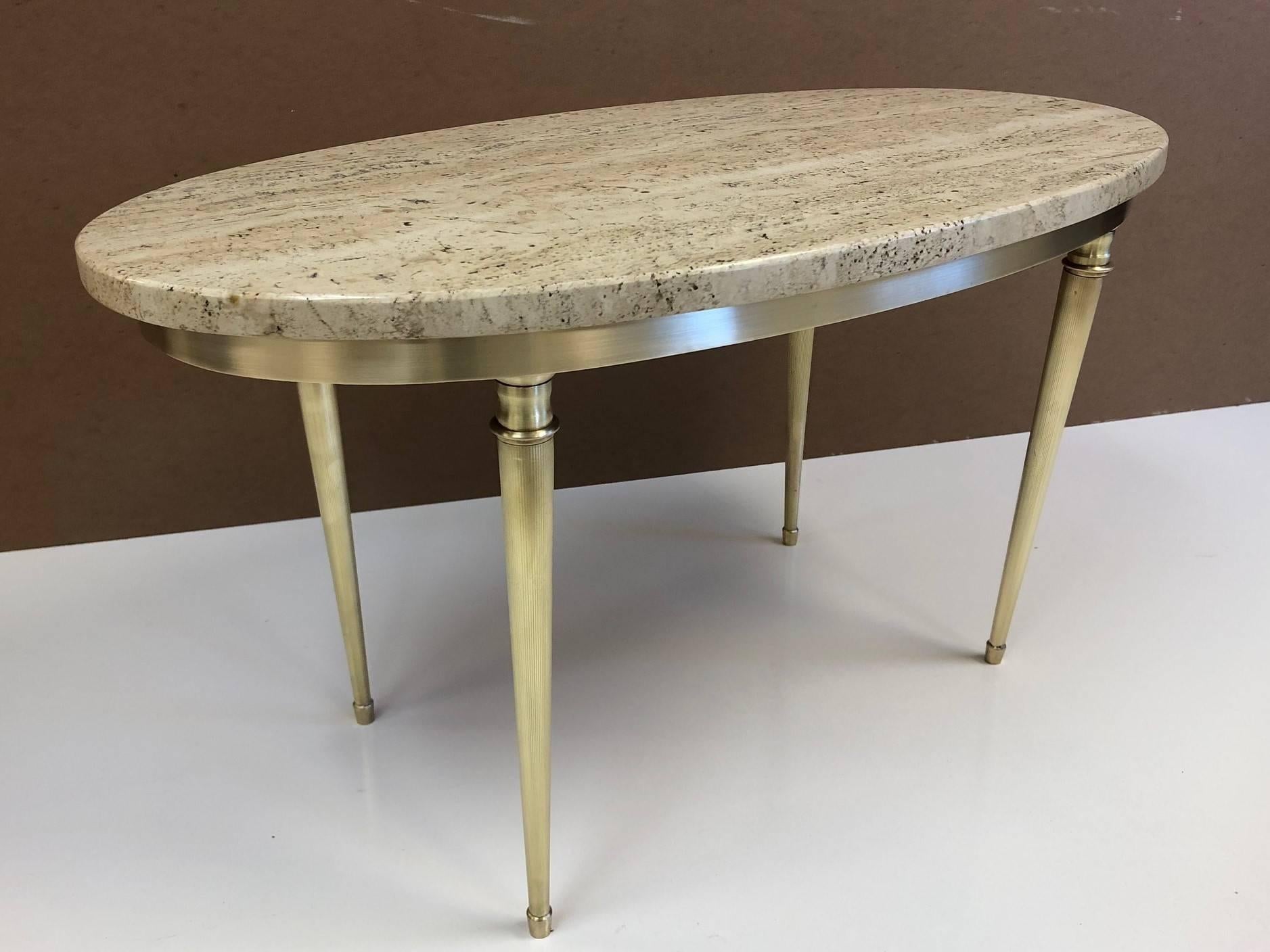 Modernist Italian travertine and brass coffee table. The frame of table is brass with an oval shaped travertine top.