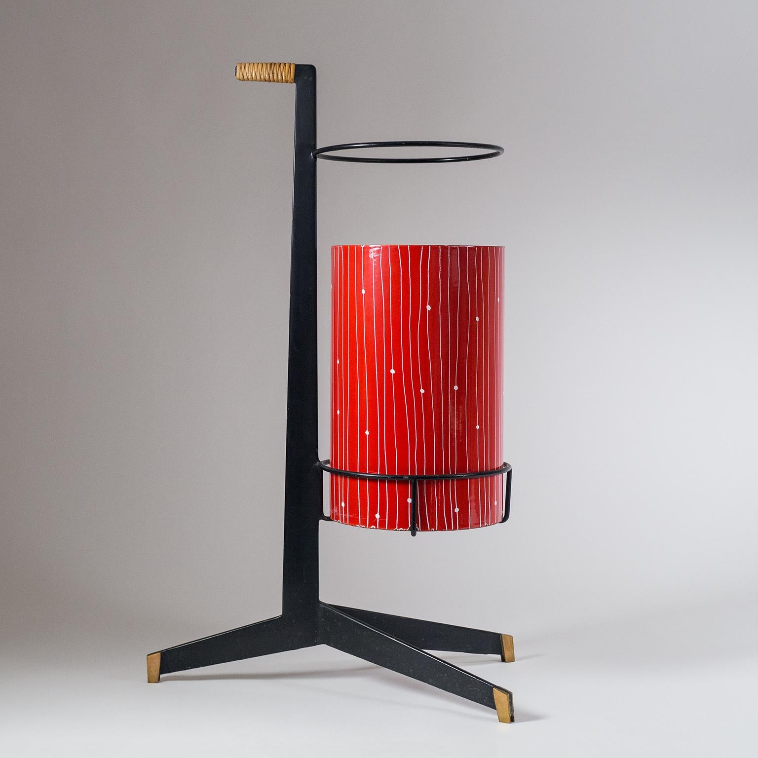 Very unique Italian umbrella stand from the 1950s. Black lacquered steel structure with brass feet and a wicker handle. The 'bucket' is enameled metal. Very good original condition with some loss to the paint and enamel along the bottom rim.
