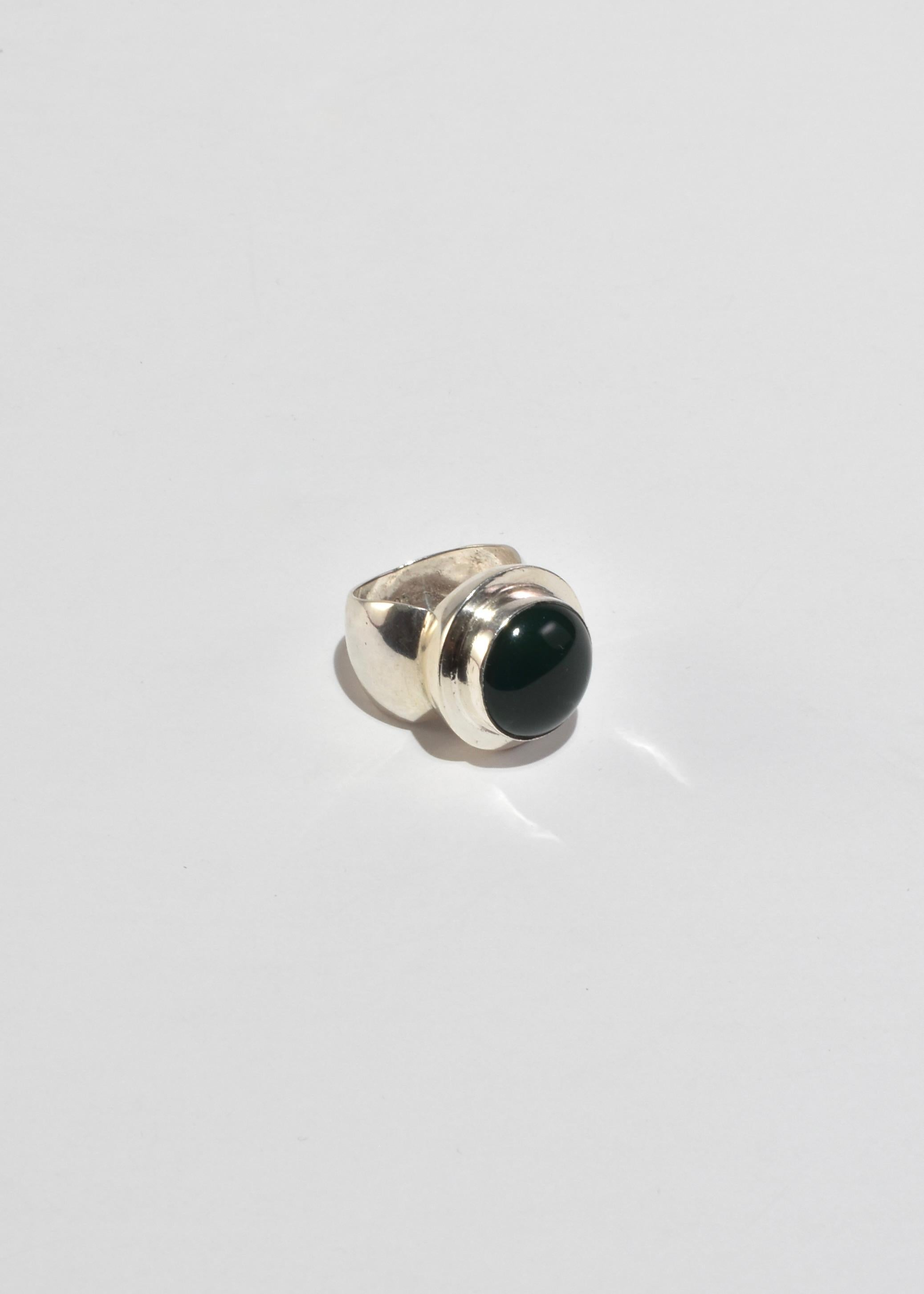 Vintage sterling statement ring with a round jade cabochon. Stamped 925.

Material: Sterling silver, jade.