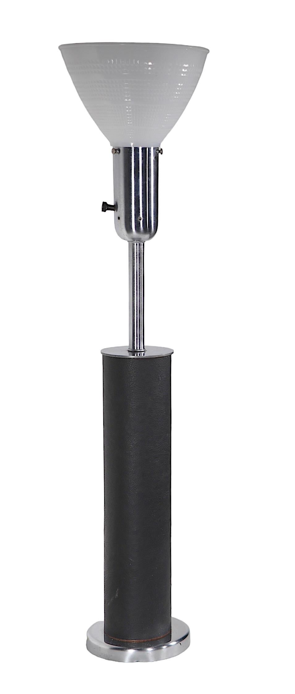 Chic and sophisticated Modernist School table lamp by Walter Von Nessen, made by Nessen Studios. The cylindrical body is wrapped in black leather,  the base is chrome and the top is brushed steel, with a white glass diffuser shade included. Circa