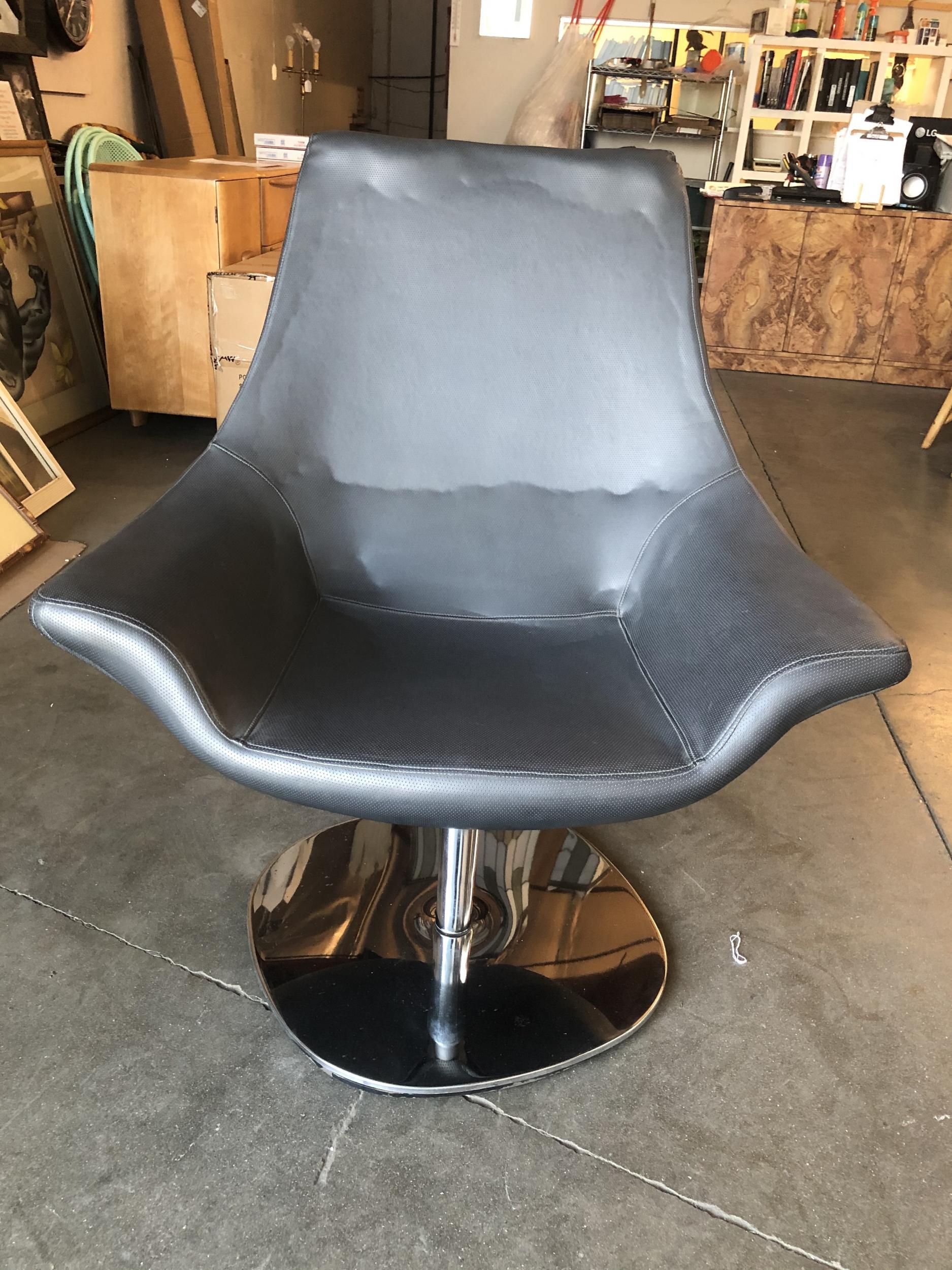 High style 1980s modern captain's lounge chair featuring a large over oversized cobra shaped back upholstered in perforated high-quality Naugahyde with chrome base. Perfect for the Memphis lounge room looking for something to balance out the room.