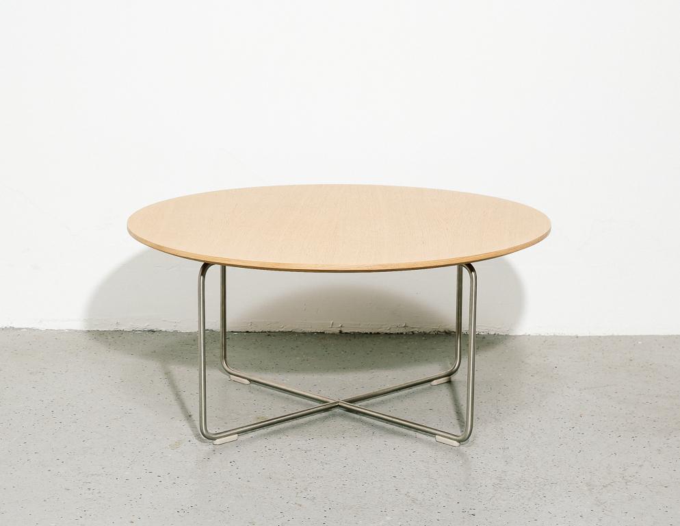 Vintage low coffee table in a modernist style, in the style of Fritz Hansen or Herman Miller. Round ash top atop a steel rod base.