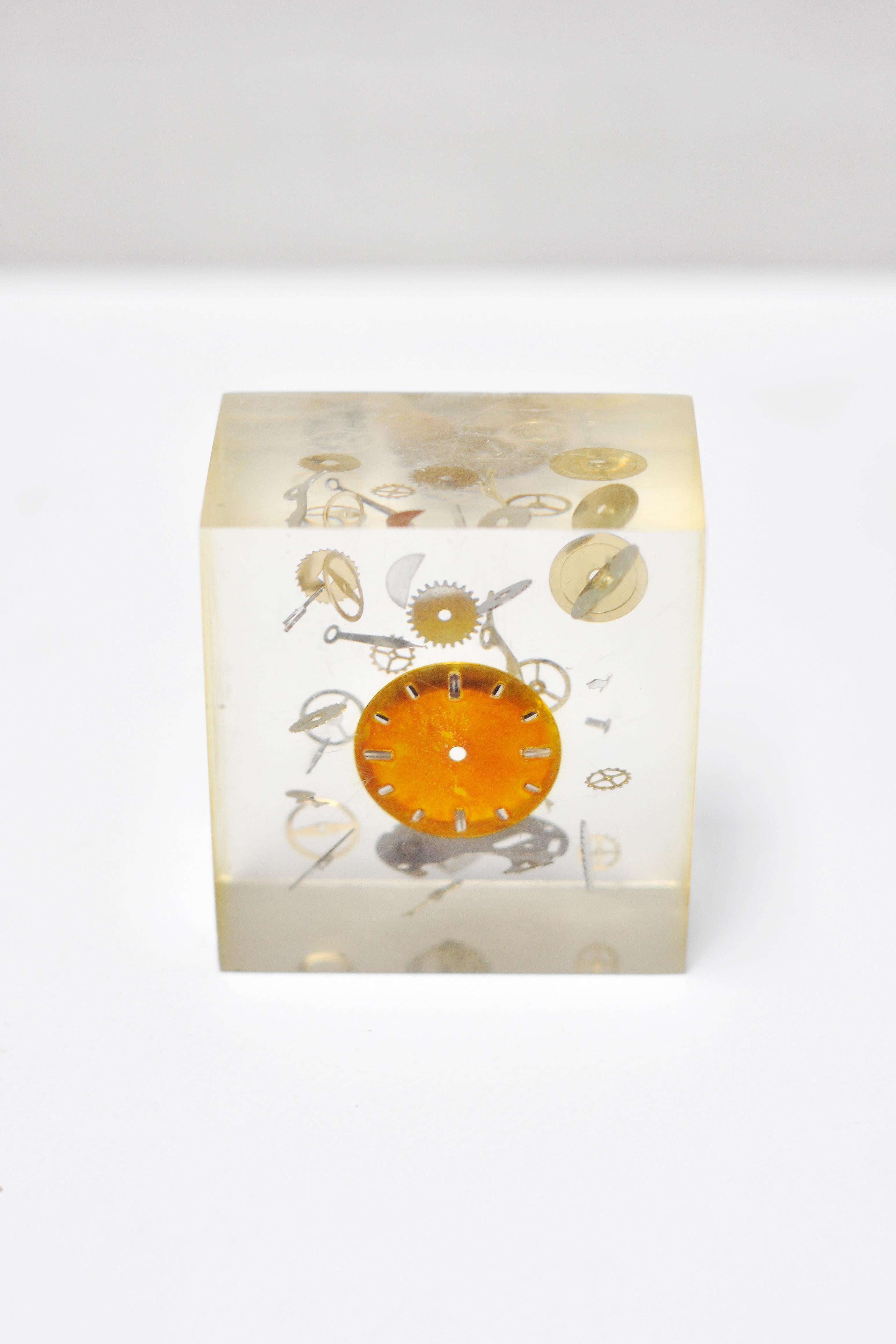 A rarely seen cube object in resin and Lucite by the French artist Pierre Giraudon. Shows an 'exploded clock' with all detailed components. A very decorative object.

In good condition, occasional scuffs/marks on the surface which do not take away