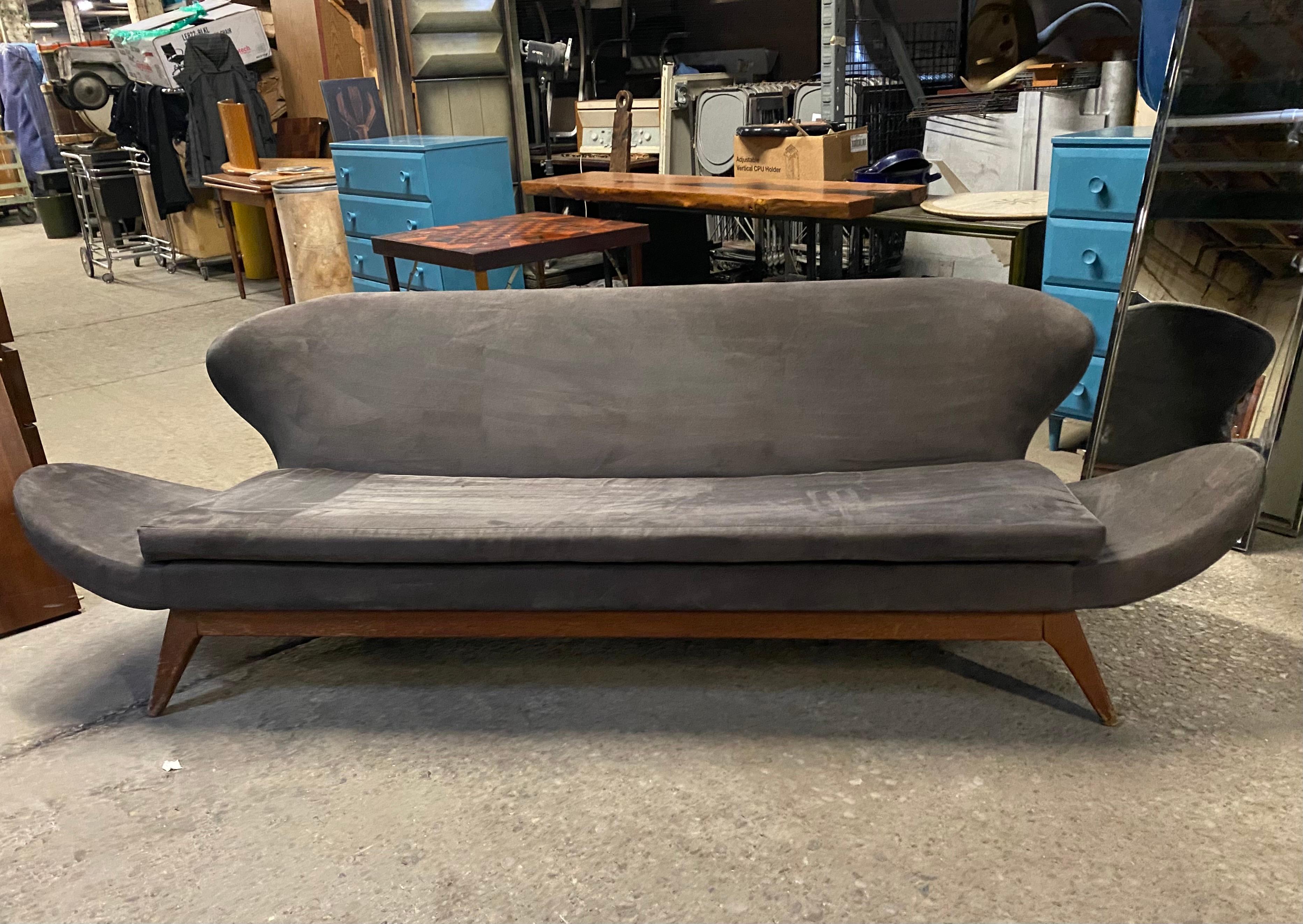This rare Classic Mid-Century Modern sofa was designed by Luigi Tiengo and produced by the Canadian manufacturer Cimon in 1963. The sculptural shape of the elongated arms, the winged back and the slightly inclined position of the seat give the sofa