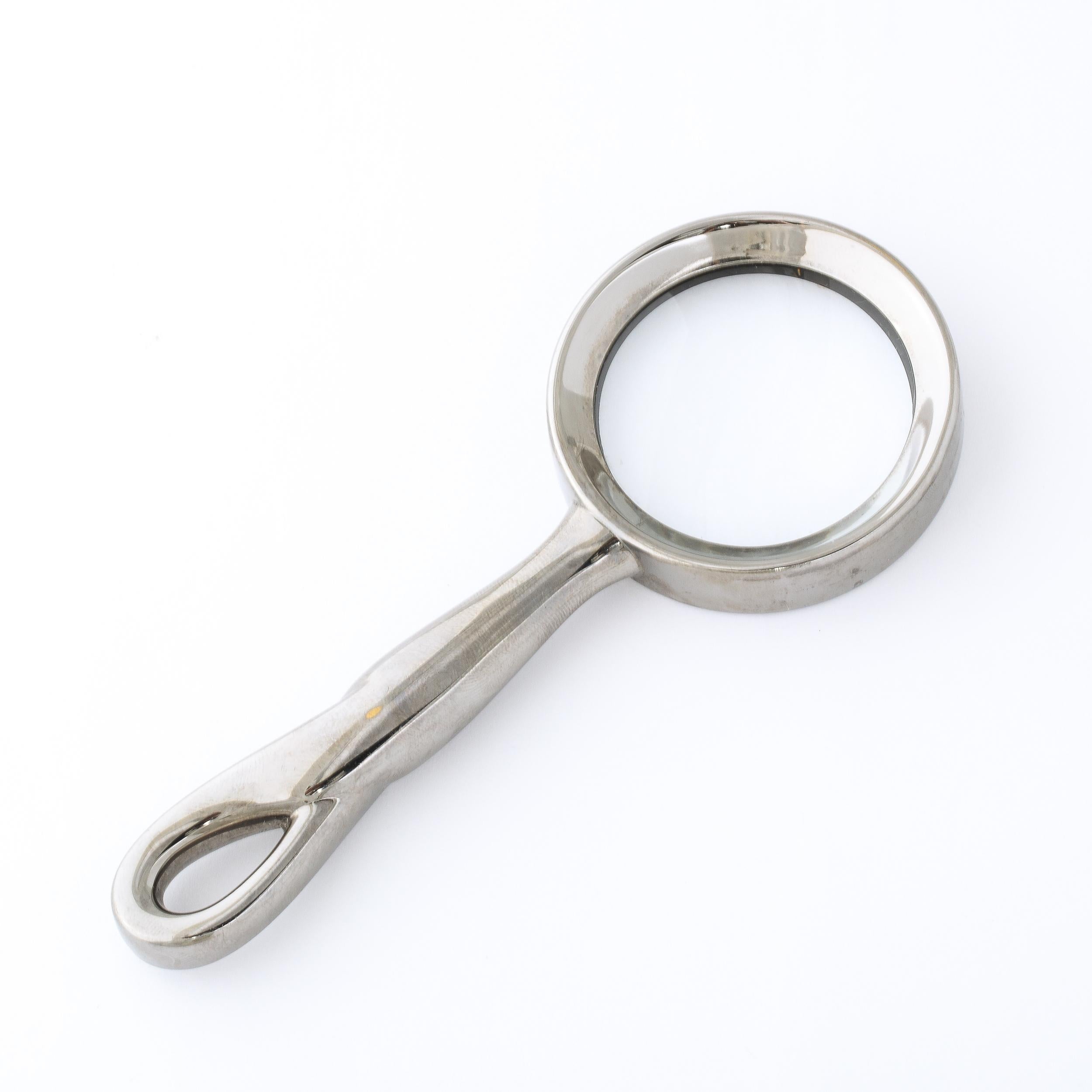 This elegant Modernist Magnifying Glass by Elsa Peretti in the Padova Pattern for Tiffany and Co. originates from the United States, Circa 1985. Featuring a gleaming and absorbing gunmetal finish, the handle is formed in an amorphic sculptural twist