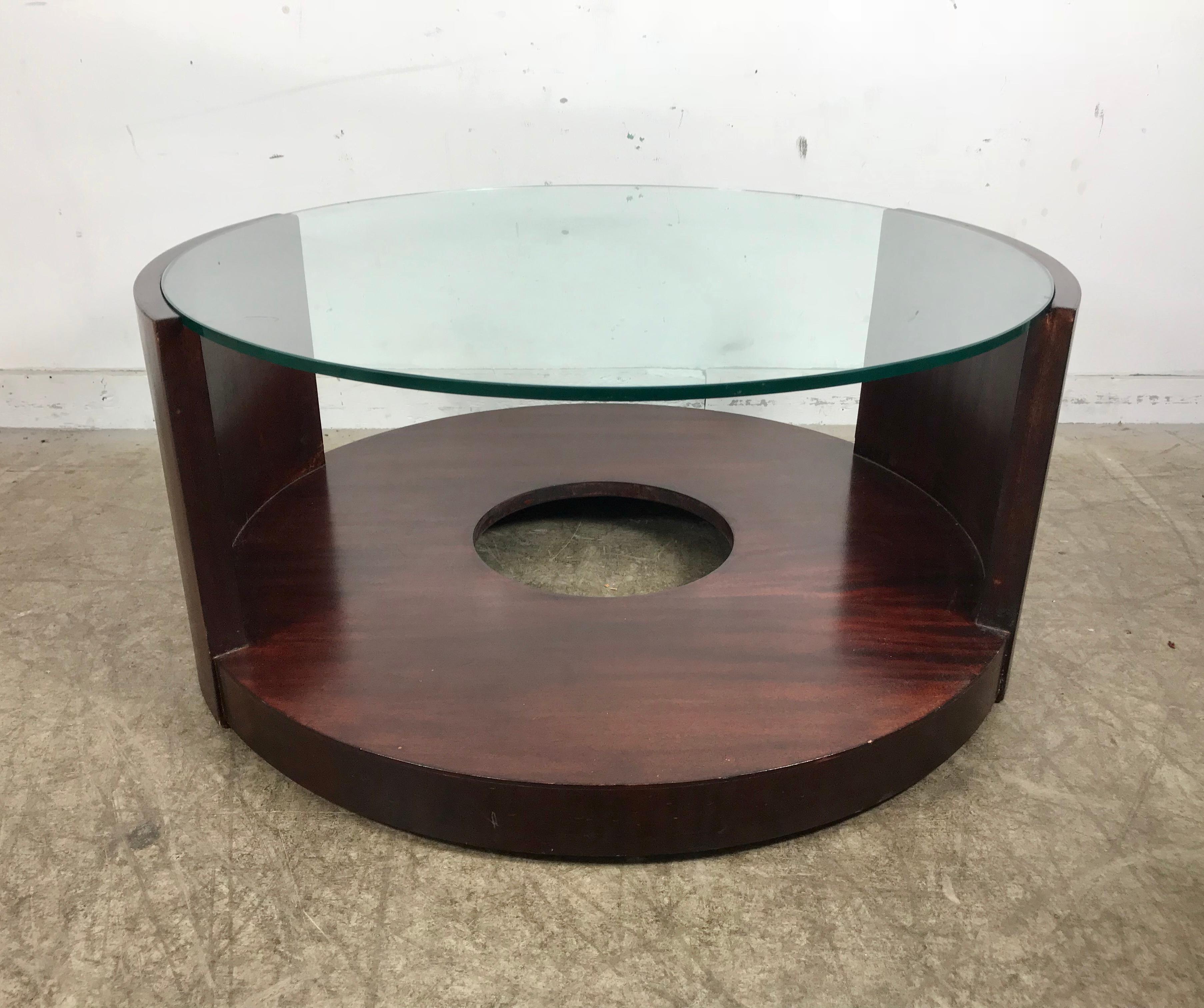 Stunning, modernist mahogany and glass round cocktail table designed by Gilbert Rhode, circa 1939. Amazing Minimalist design, important transitional period from Art Deco to modern, possibly introduced at the 1939 Worlds Fair. Hand delivery avail to