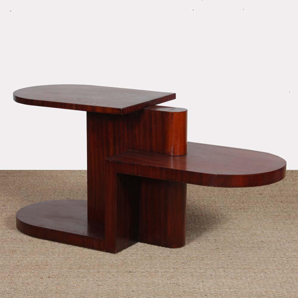 This modernist mahogany coffee table dates from the 1930s. It features three levels of top. This piece of wooden furniture is in good condition.
