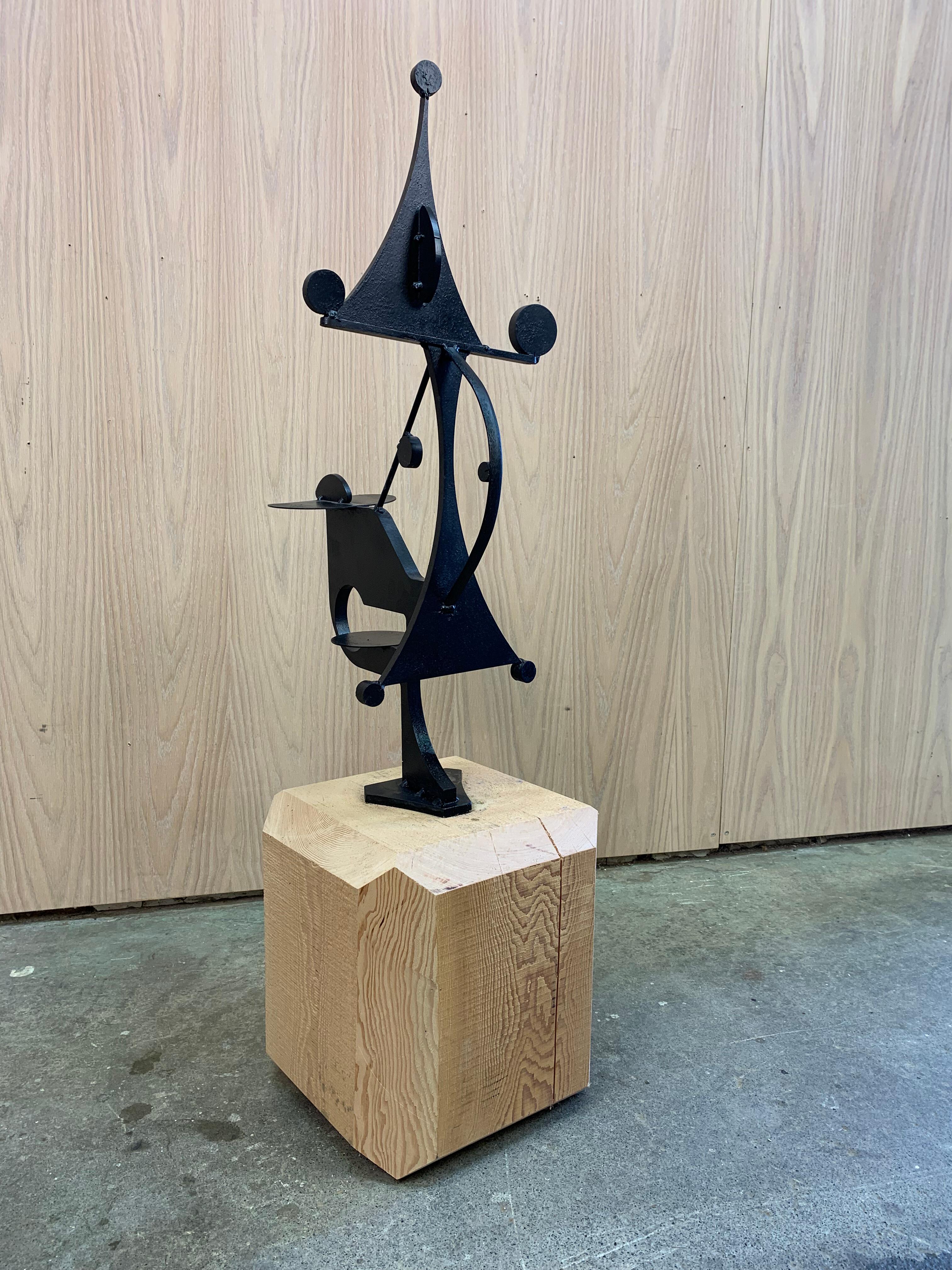 Questa accattivante scultura moderna di metà secolo di Jay McVickers bilancia una geometria audace con un senso di movimento giocoso. Realizzato in metallo annerito e montato su un blocco di legno grezzo e sfaccettato, il pezzo incanala lo spirito