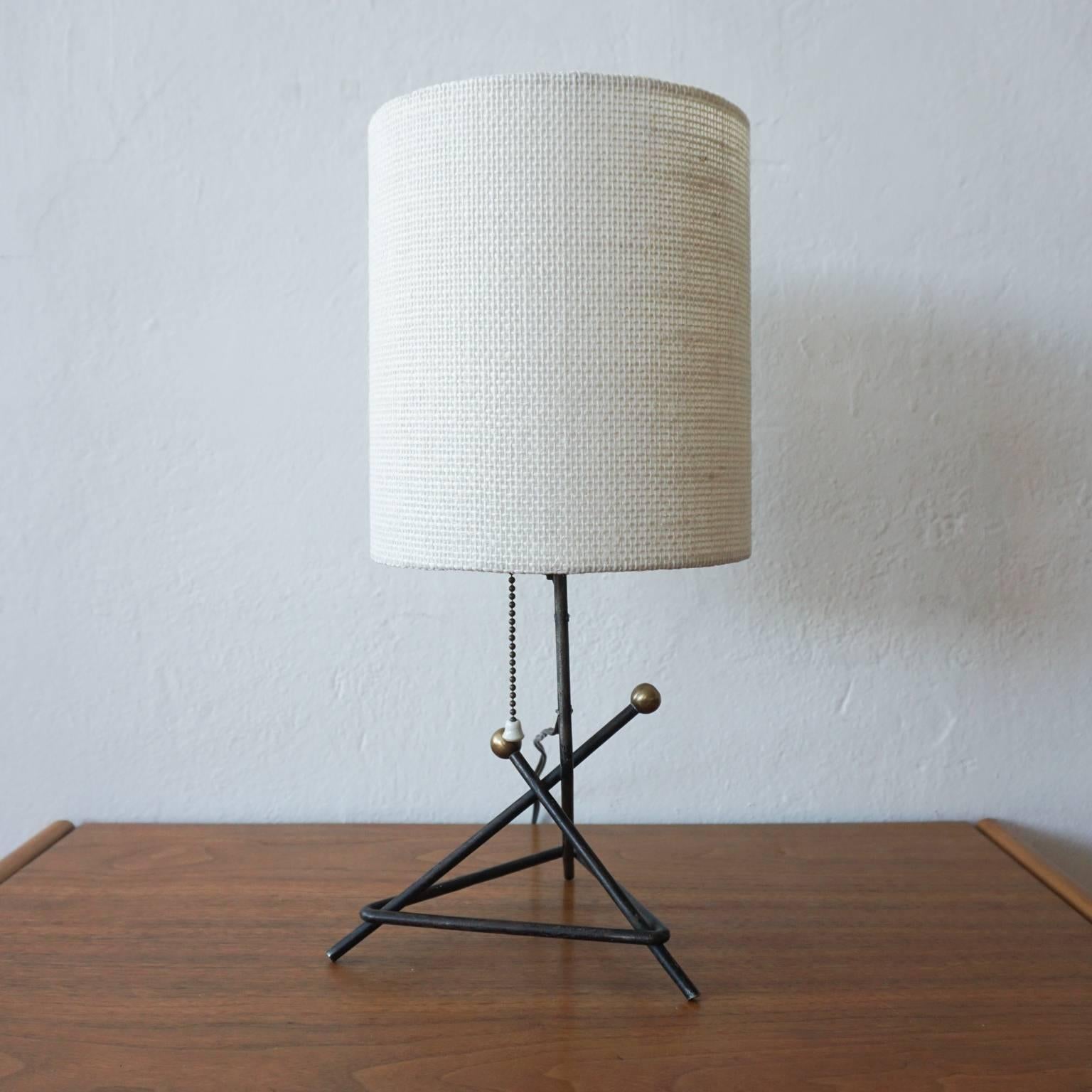 1950s iron table lamp with brass elements. Original finish to the lamp, with a new shade, 1950s.

Measurements include the shade.