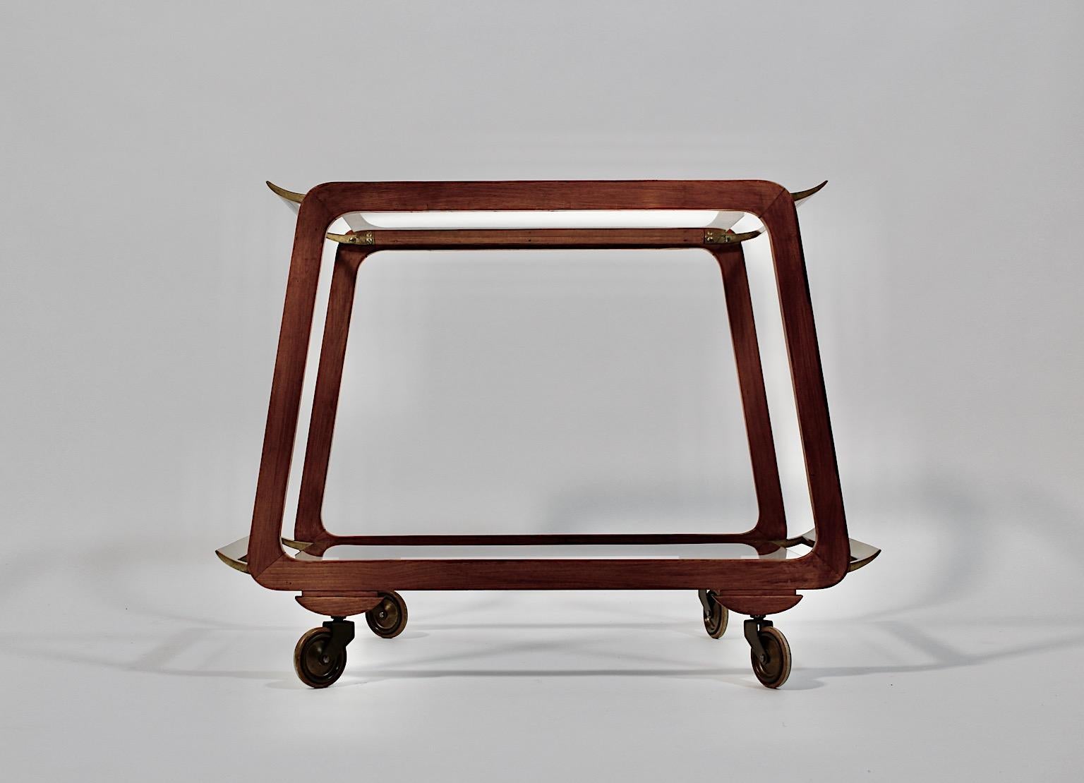 Modernist Mid century Modern vintage bar cart or tea cart from brass
and ash attributed to Oswald Haerdtl 1960s Vienna.
An amazing bar cart from beautiful brass and ash wood in warm brown color with two removable clear glass plates in rectangular