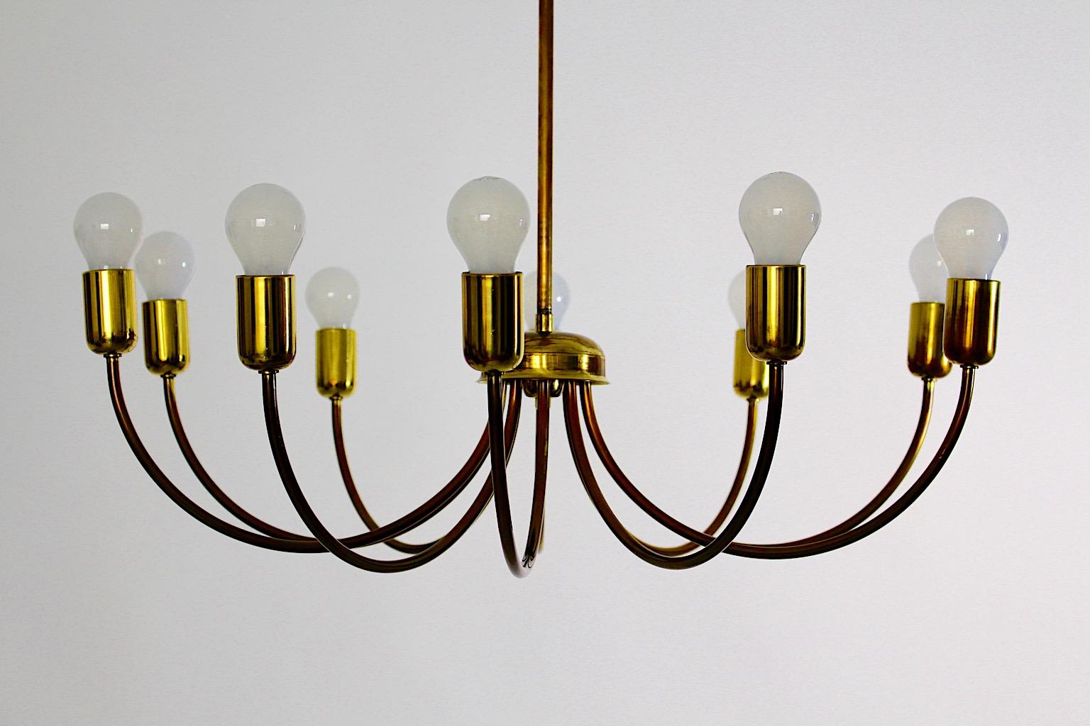 Modernist Mid Century Modern vintage brass chandelier with curved 10 arms  1950s Austria.
A wonderful chandelier from brass with ten curved arms with E 27 sockets and a great possibility to minimize the light blaze from 10 ( ten ) bulbs to five ( 5