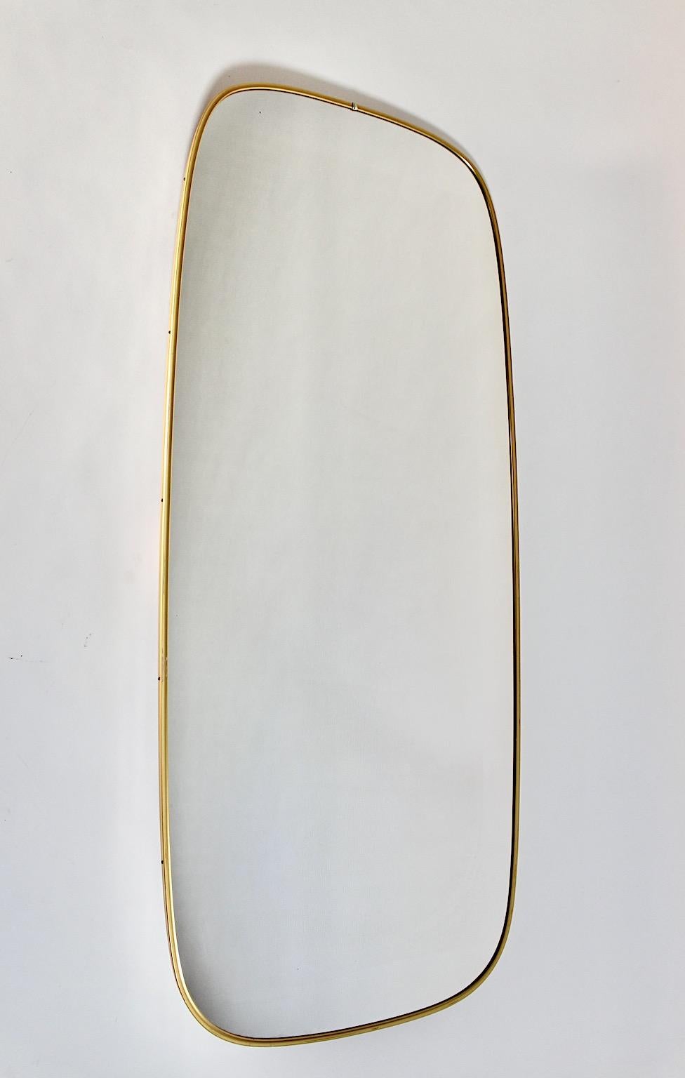 Specchio vintage di dimensioni enormi a tutta lunghezza in stile modernista del Mid Century Modern 
con un'altezza di 120 cm che presenta una struttura in metallo ottonato con bordi leggermente curvi di forma rettangolare.
Un bellissimo nuovo