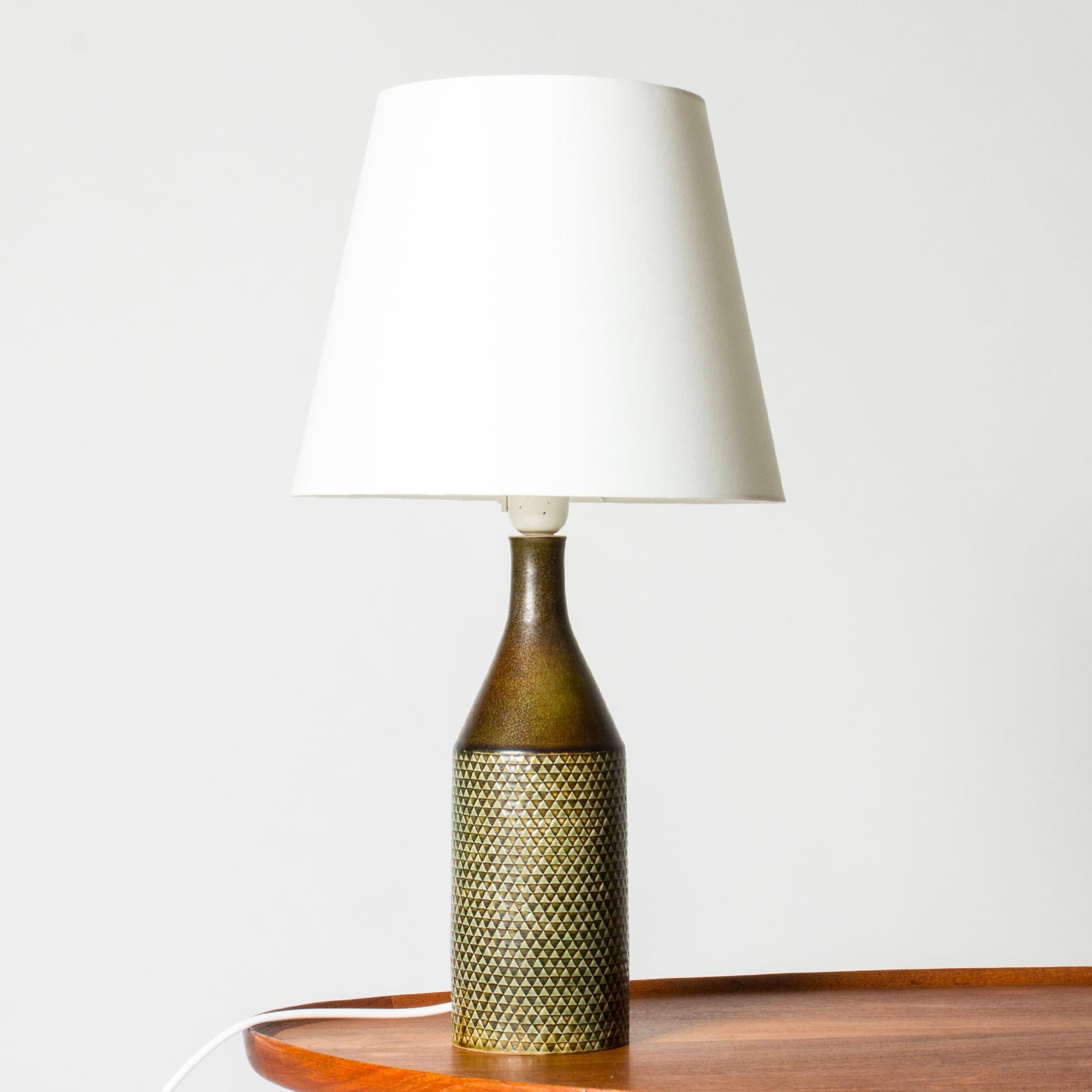 Lampe de table en grès très cool de Stig Lindberg. De forme cylindrique avec un motif en damier embossé typique de Lindberg. Glaçure brune et vert olive.