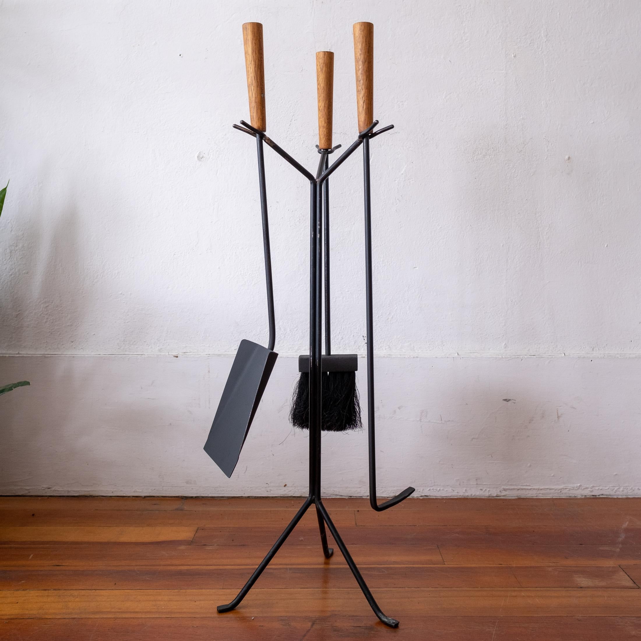 A nice small-scale modernist iron and wood fireplace tool set from the 1950s.