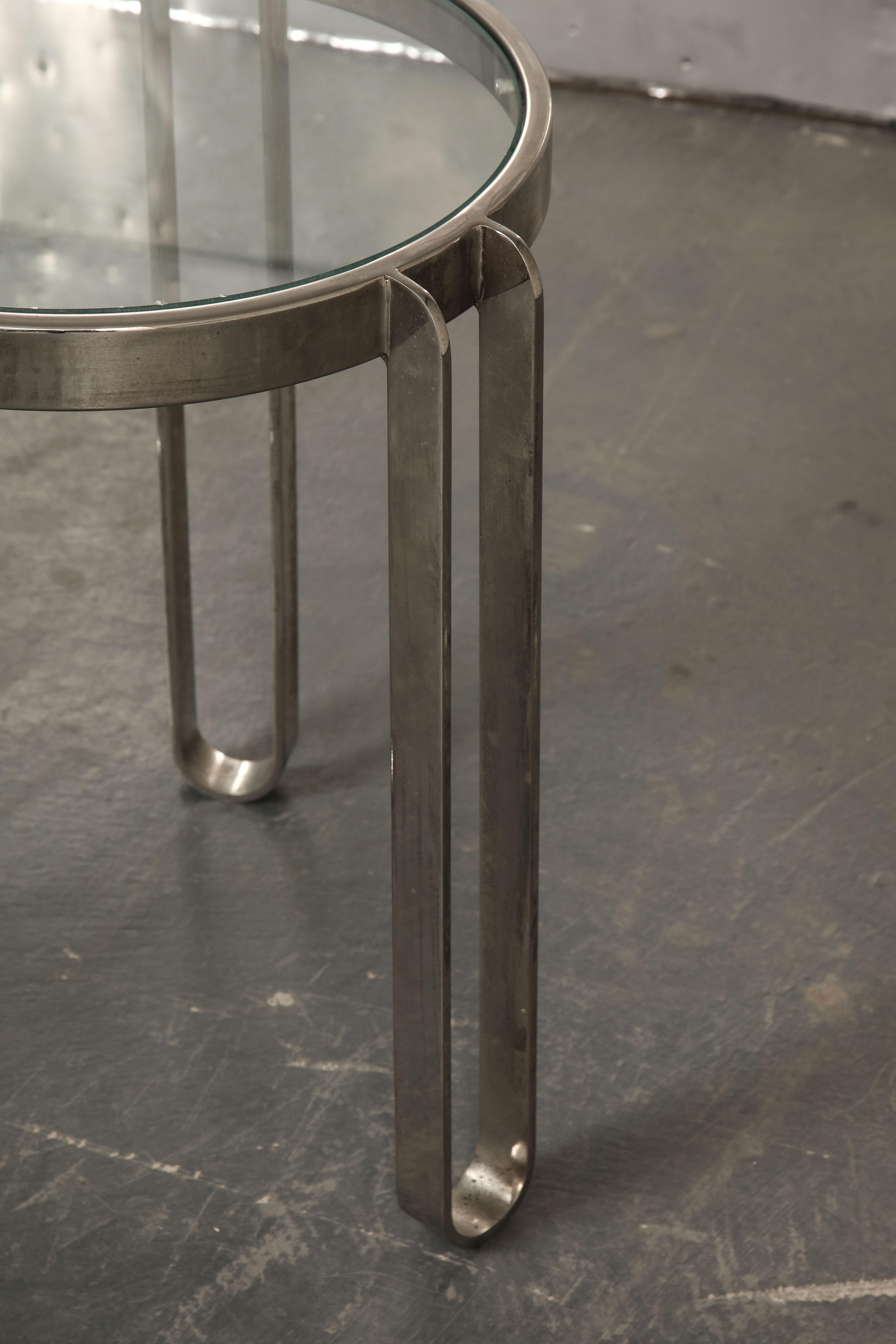 The nickel frame with three legs inset with a round glass top.