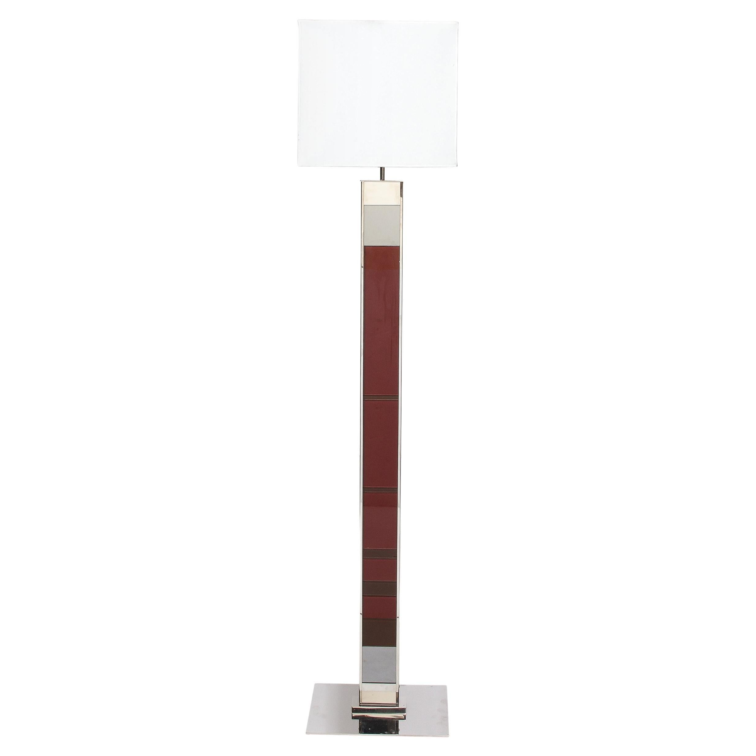 This beautiful and sophisticated modernist lamp was realized in Italy during the latter half of the 20th century. It features a polished nickel rectangular base from which a TOTEM volumetric rectilinear body ascends. The stem of the floor lamp has