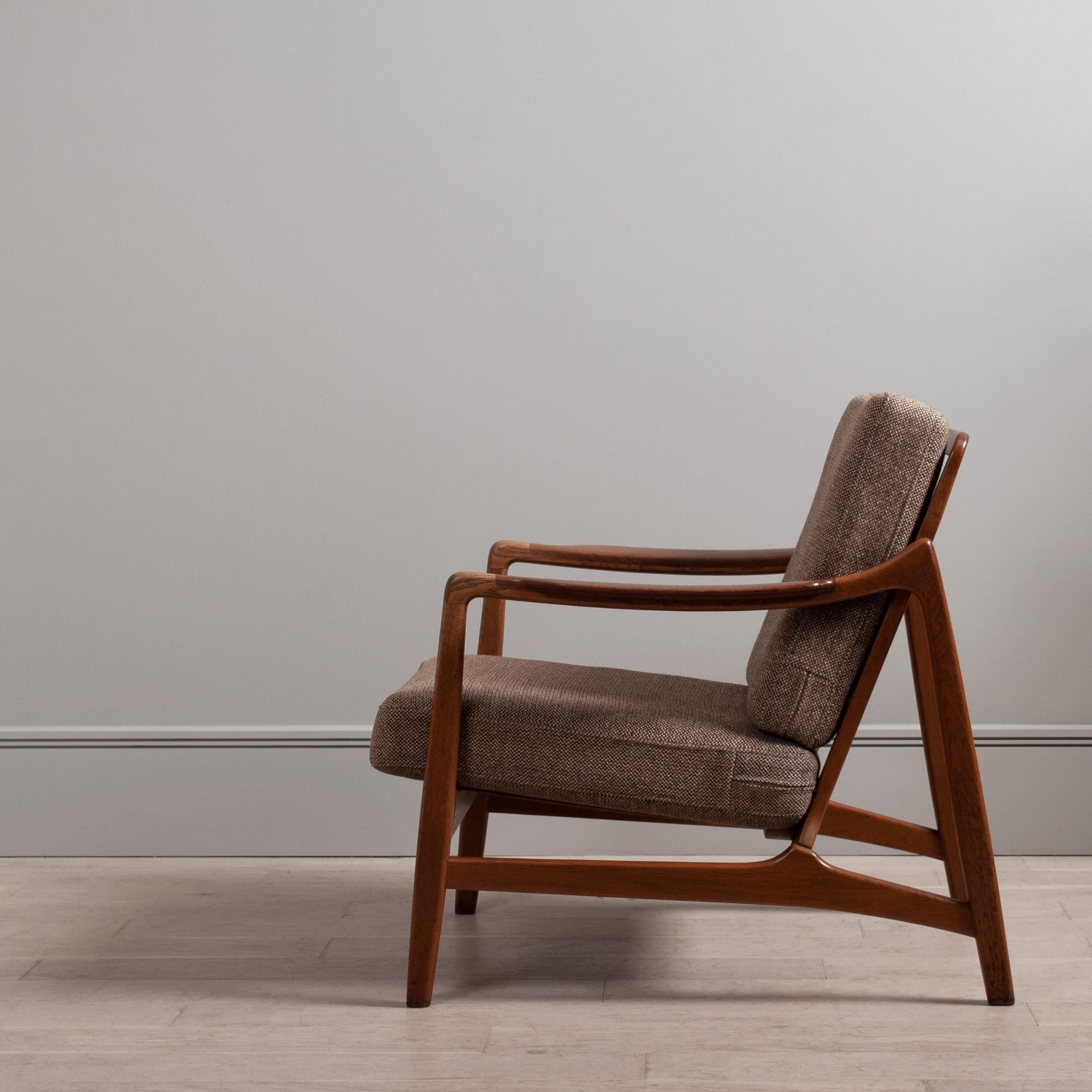 A superbly designed lounge chair by Tove & Edvard Kindt Larsen. Model 117 constructed from European oak with inset teak armrests. Price includes reupholstery in fabric colour of choice from the Isle Mill Fabric - Leather upholstery for small