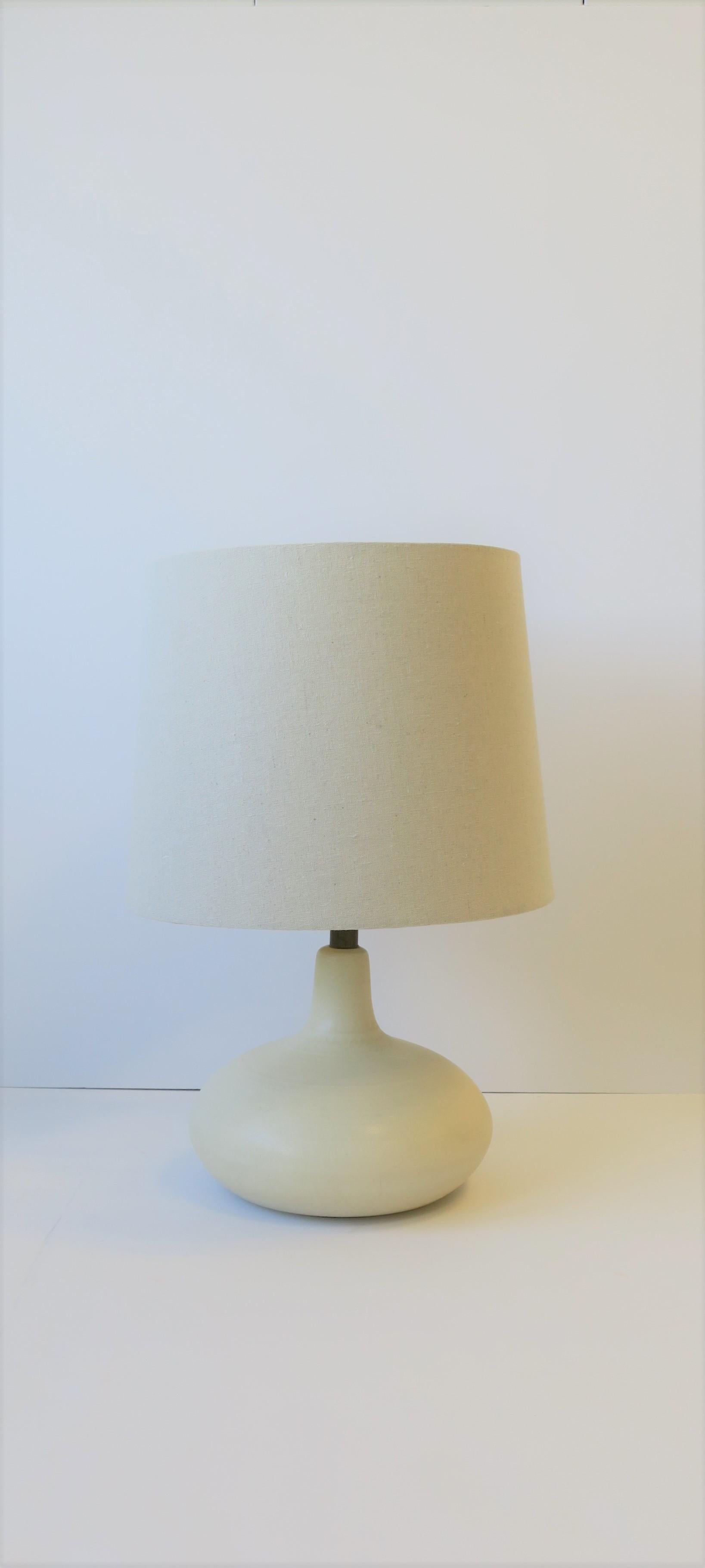 A relatively small, Mid-Century Modern period white/off-white pottery desk or table lamp, circa 1960s. 

Lamp measurements:
Diameter: 9.5