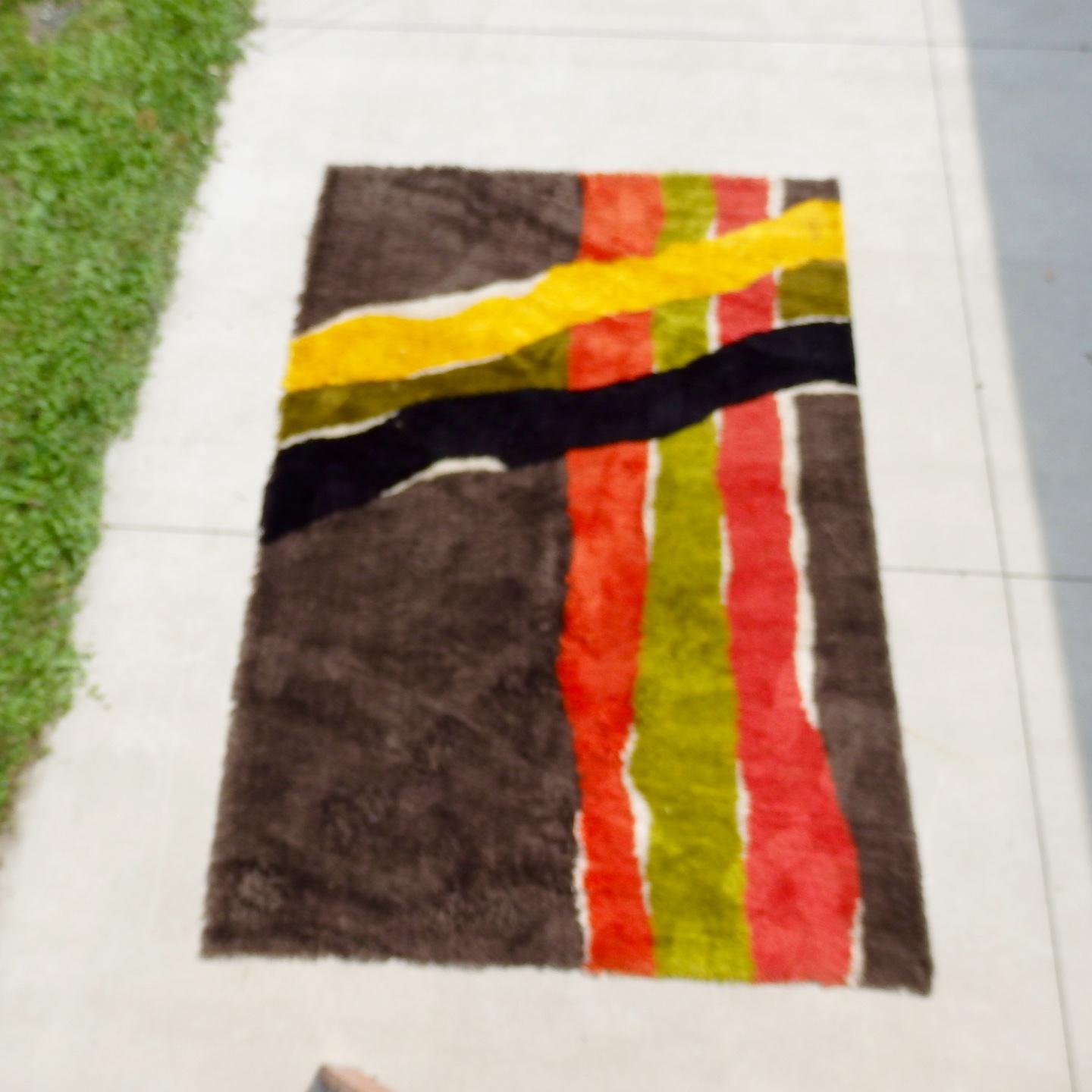 1960s abstract area rug. Excellent original condition. Brown field with orange and green lines intersected by mustard yellow and black.