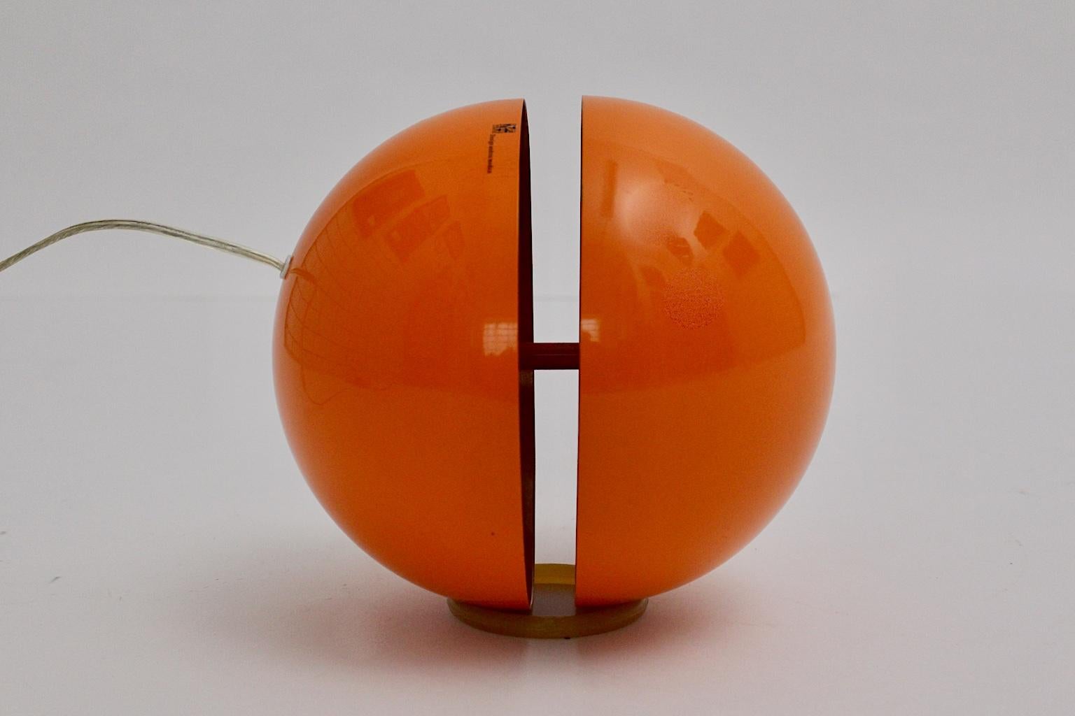 Modern orange plastic globe table lamp by Andrea Modica for Lumess Switzerland features inside a plexiglass disc which separates two disc halves.
Also the table lamp is labeled.
One E 27 socket and on/off switch
Furthermore a loose rubber ring