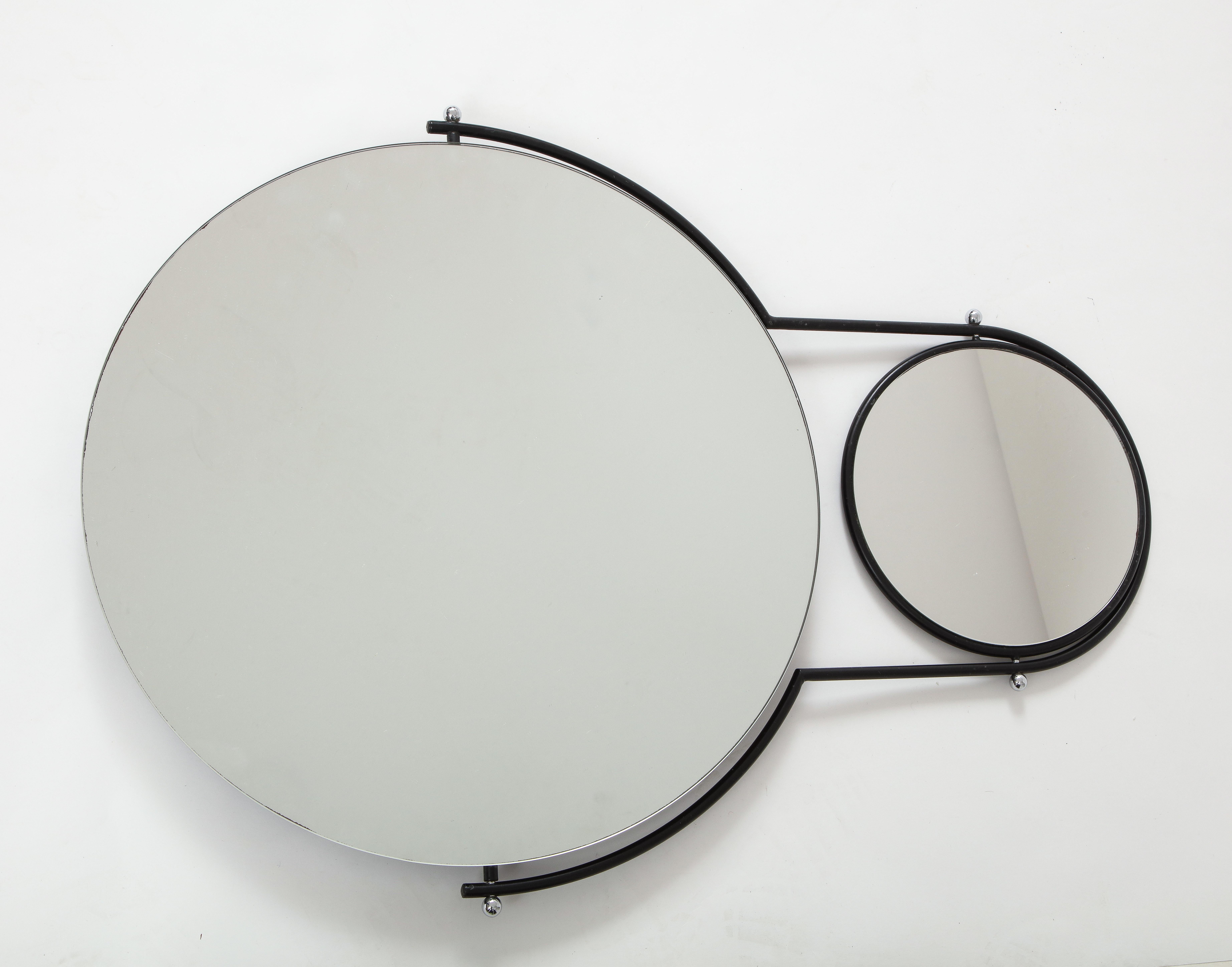 An ingenious designed modernist 'Orbit' wall mirror by Rodney Kinsman for Bieffeplast. This mirror allows for an angled view through the accompanying two sided mirror that is attached on a swiveling black metal bracket. The work symbolizes the moons