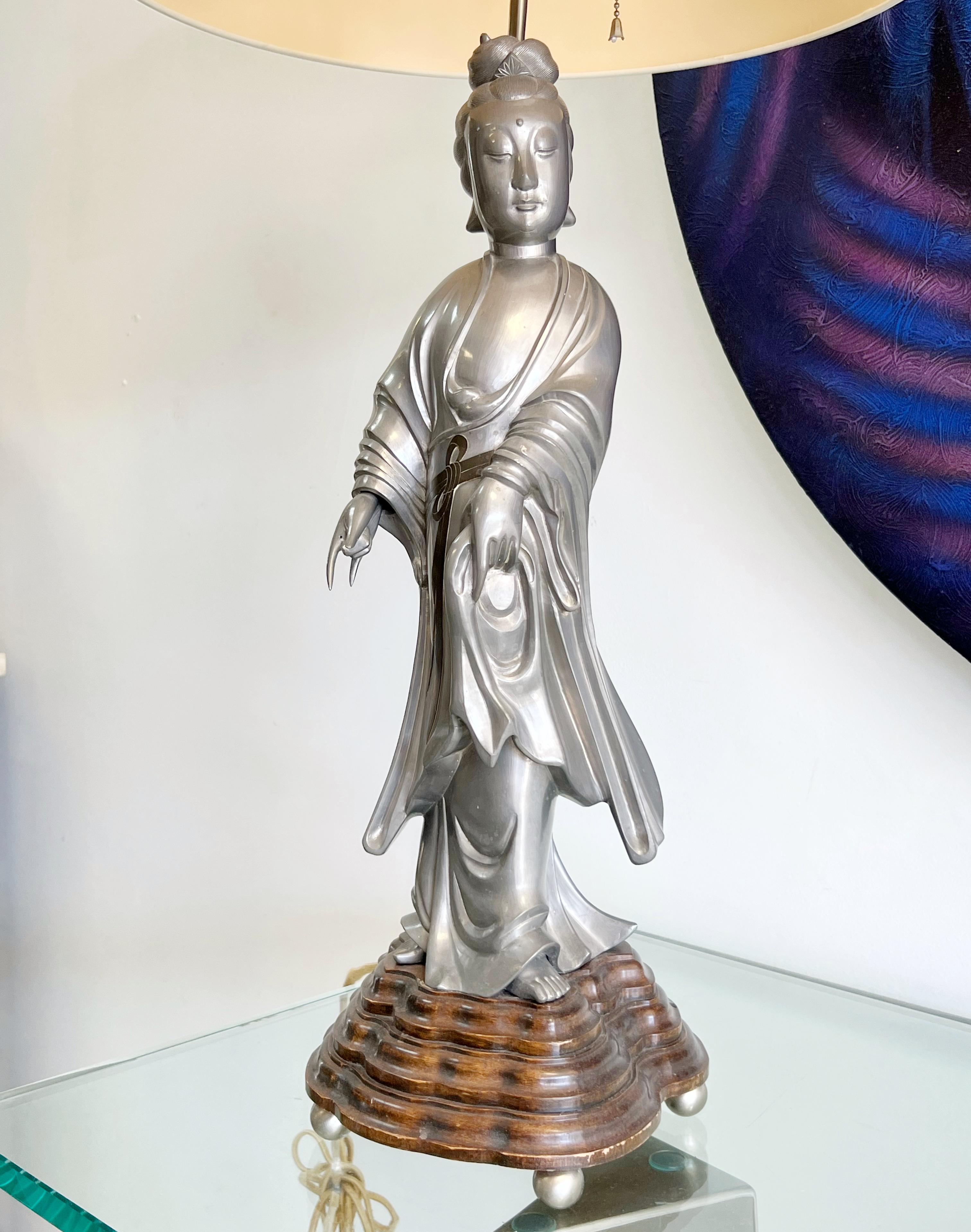 A beautiful lamp. The large figure seems carved out of a block of pewter. On a stepped wood base. 