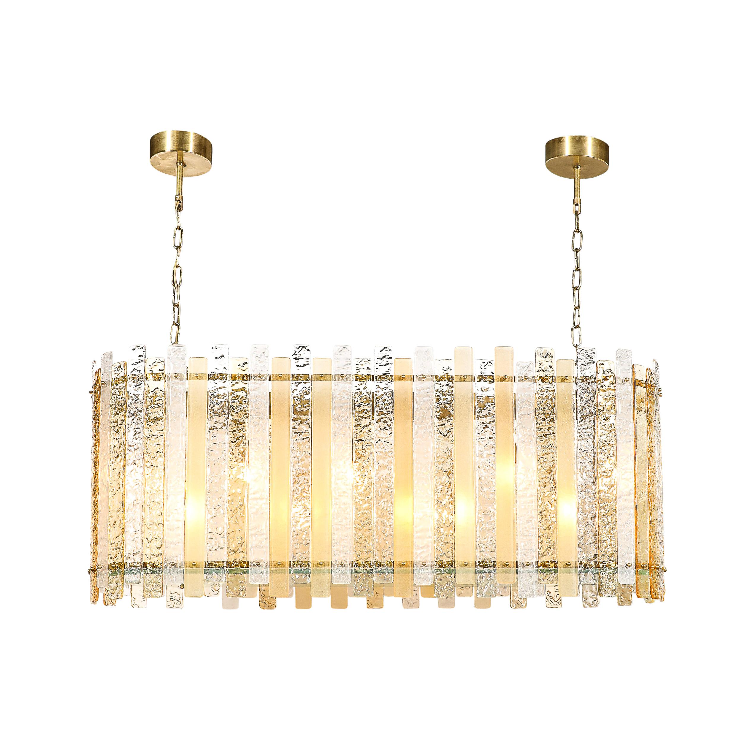 Cet élégant luminaire en verre de Murano soufflé à la main, fabriqué en Italie au 21e siècle, offre un mélange captivant de design moderniste et de techniques traditionnelles de verrerie vénitienne. La forme ovoïde du luminaire lui confère une forme