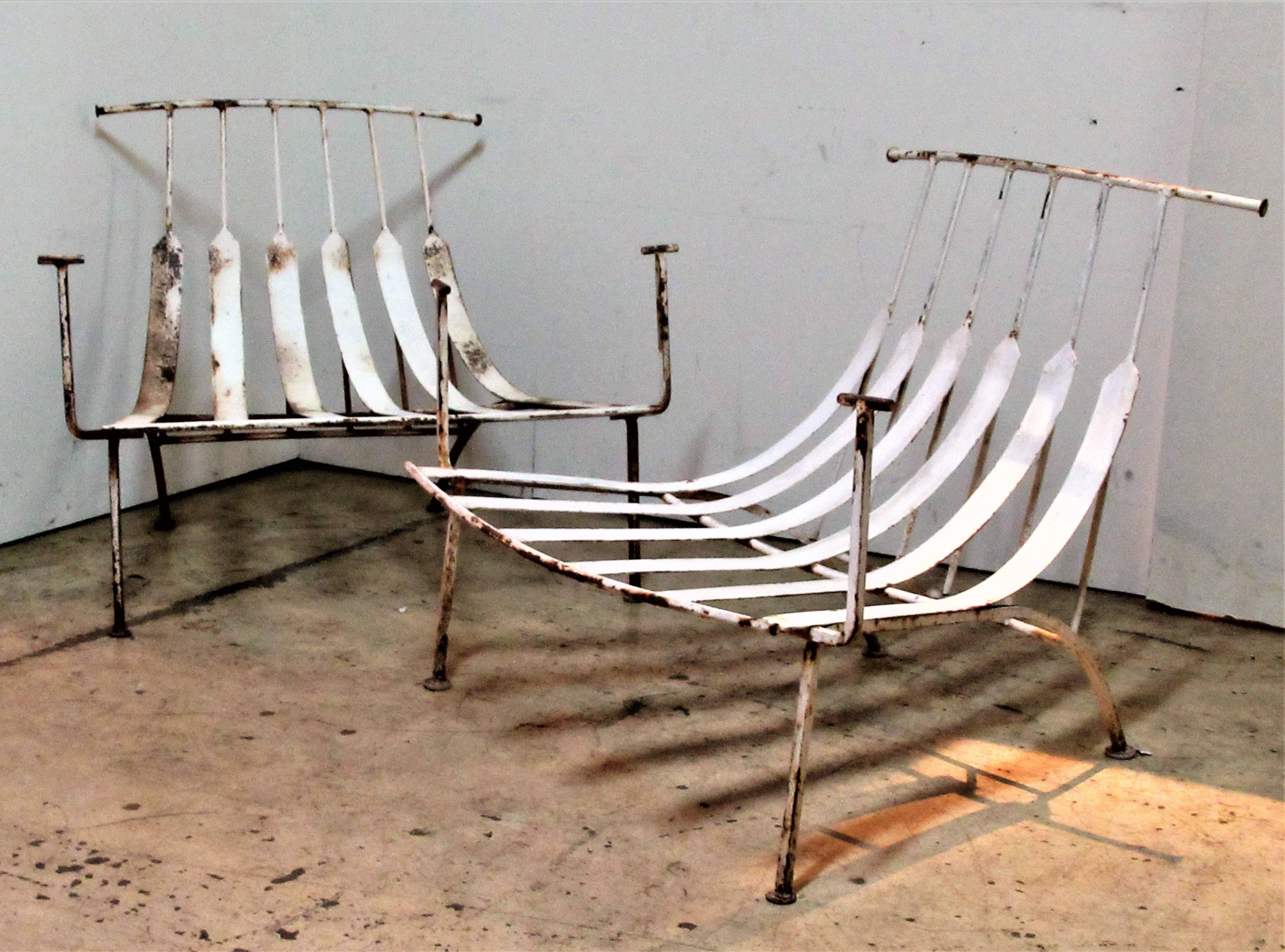 A spectacular pair of wrought iron lounge chairs with bull horn shaped backs / raised arms and low slung flat spring steel seats. These will take sling straps on armrests that will attach to outer top horn backs and loose cushion on seat frame.