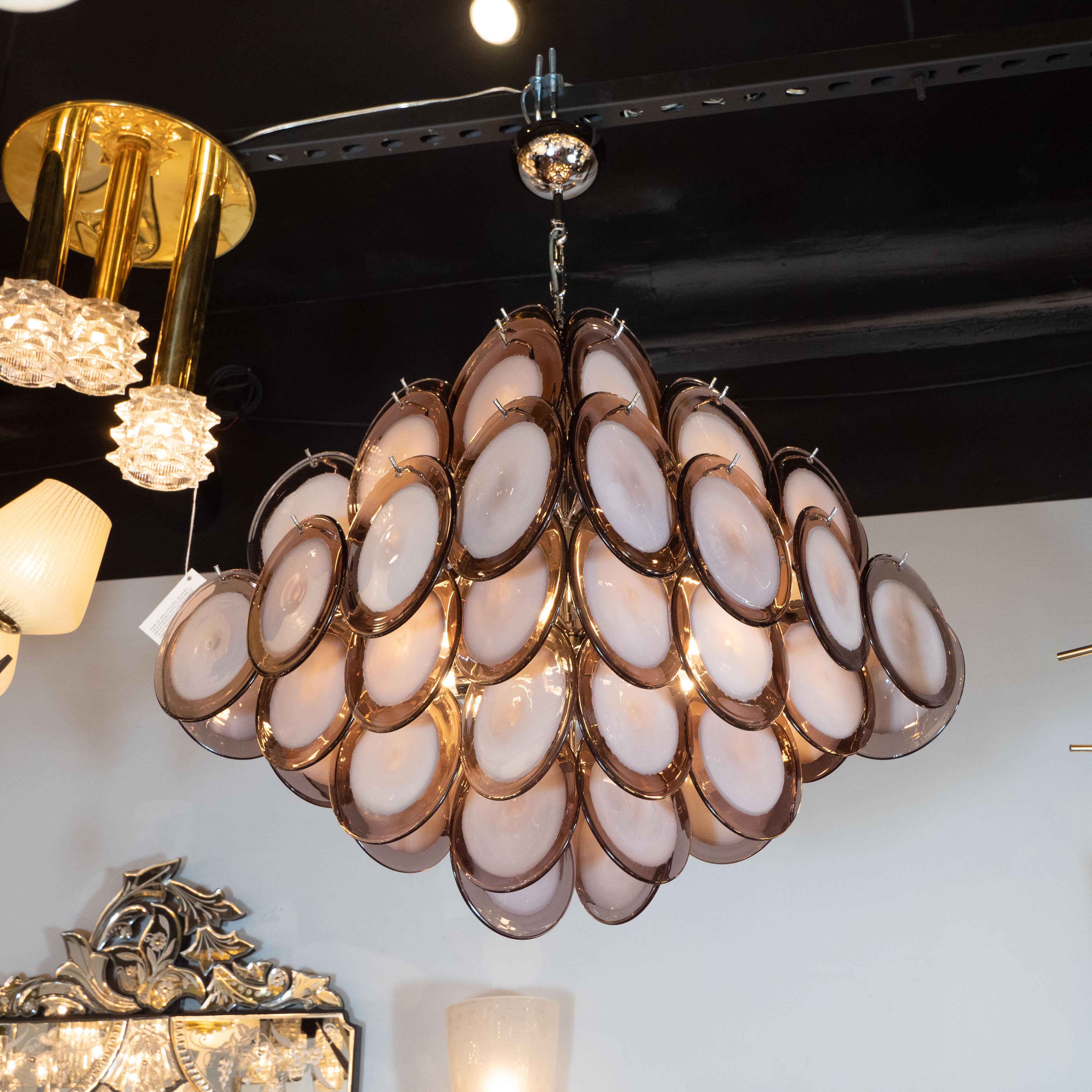 This elegant chandelier was realized in Murano, Italy- the island off the coast of Venice renowned for centuries for their superlative glass production. It features a pagoda style body- consisting of an abundance of Vistosi style discs with opaque
