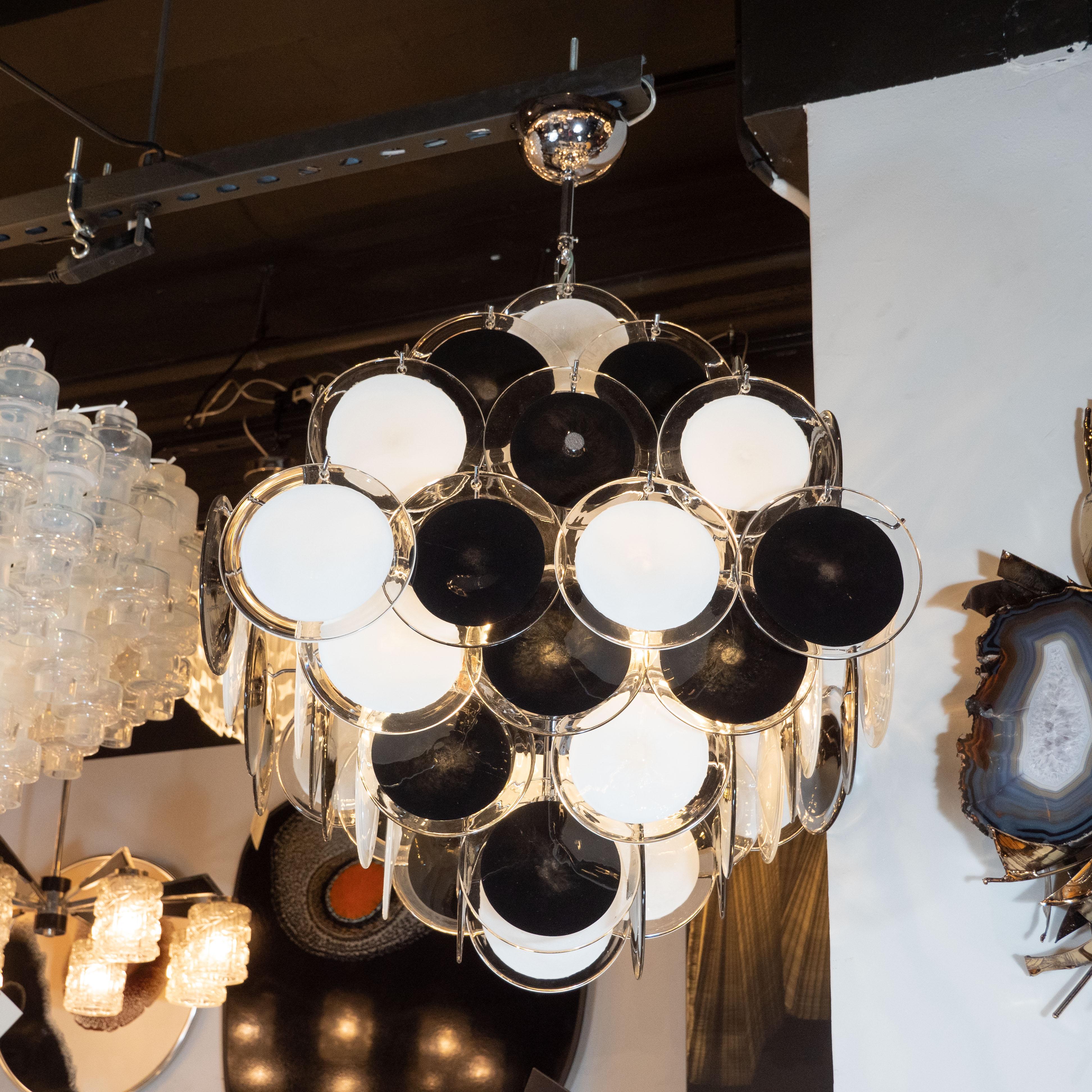 This elegant chandelier was realized in Murano, Italy, the island off the coast of Venice renowned for centuries for their superlative glass production. It features a pagoda style body, consisting of an abundance of Vistosi style discs with black