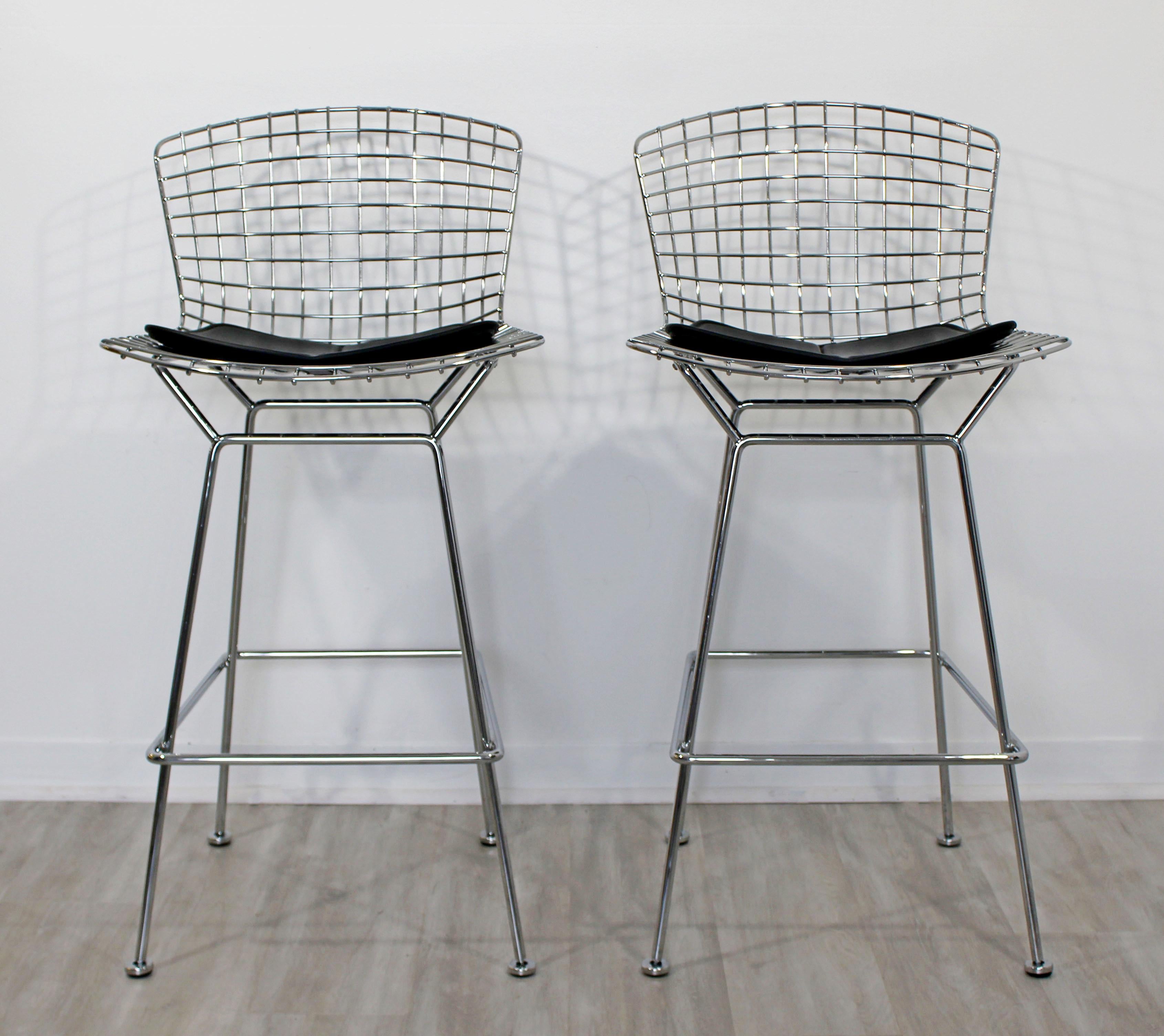 For your consideration is a marvelous pair of Harry Bertoia for Knoll bar stools, made of chrome and with angular black vinyl seat, re-issued by Architectura in 2001. In excellent condition. The dimensions are 21