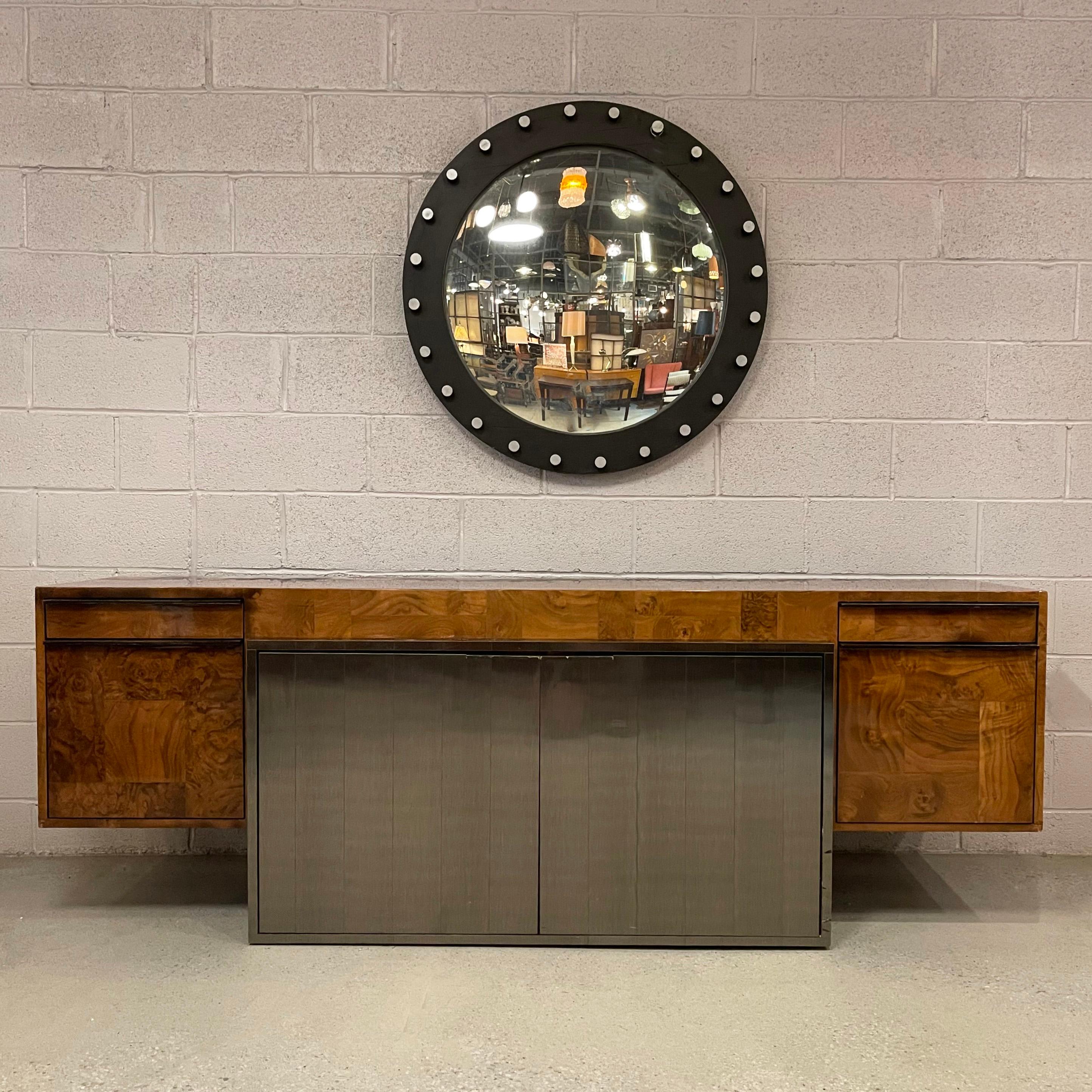Stunning, modernist, patchwork burl, credenza by Paul Evans for Directional features a high sheen laminate finish with 48 inch wide, gunmetal steel center doors and two 16 inch wide side drawers on either side edged in black laminate. The credenza