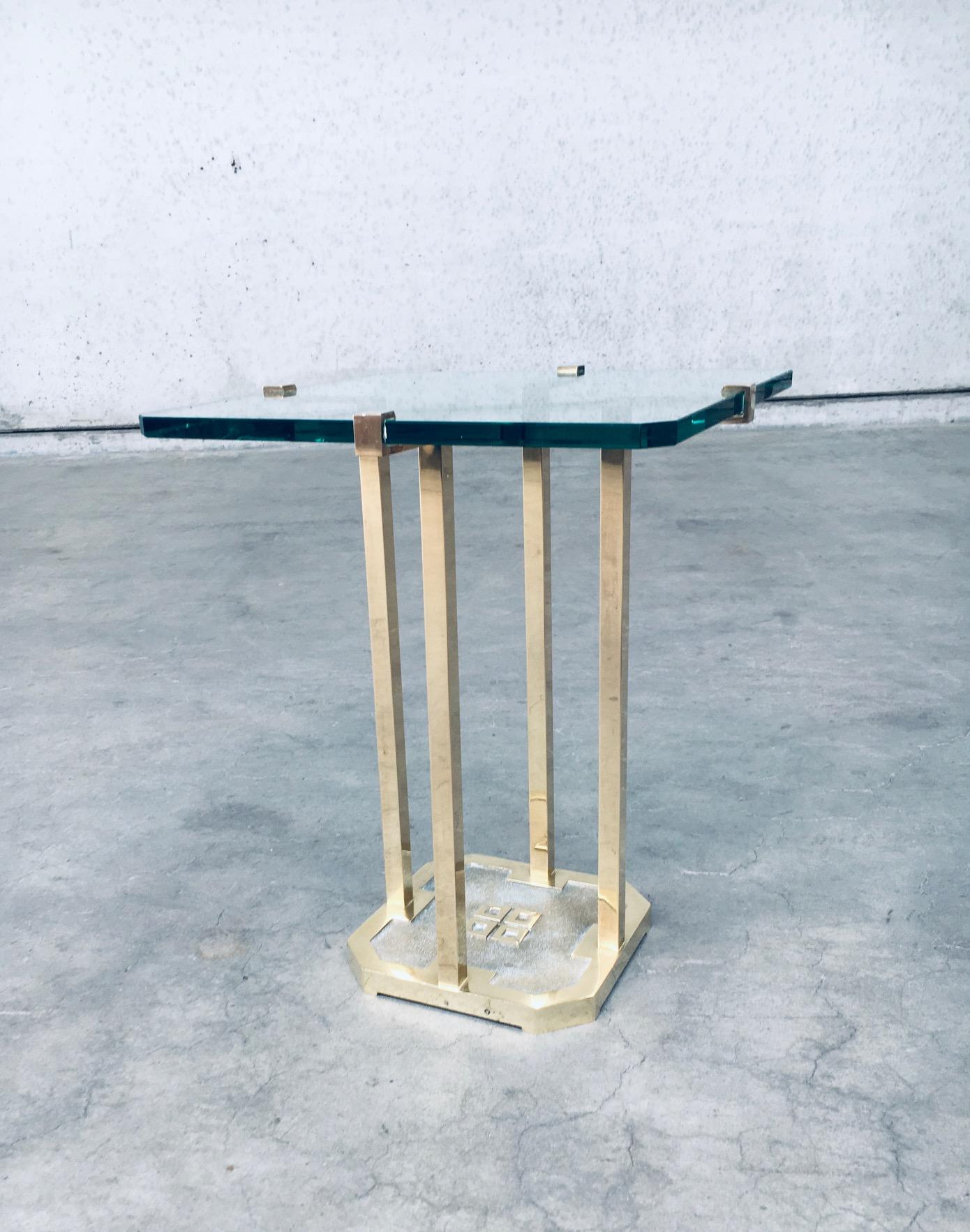 Vintage Postmodern Design Table d'appoint moderniste modèle T18 par Peter Ghyczy. Fabriqué aux Pays-Bas, dans les années 1970. Laiton patiné et verre taillé épais. En très bon état. Mesures : 41cm x 41cm x53cm.

Après la révolution hongroise de