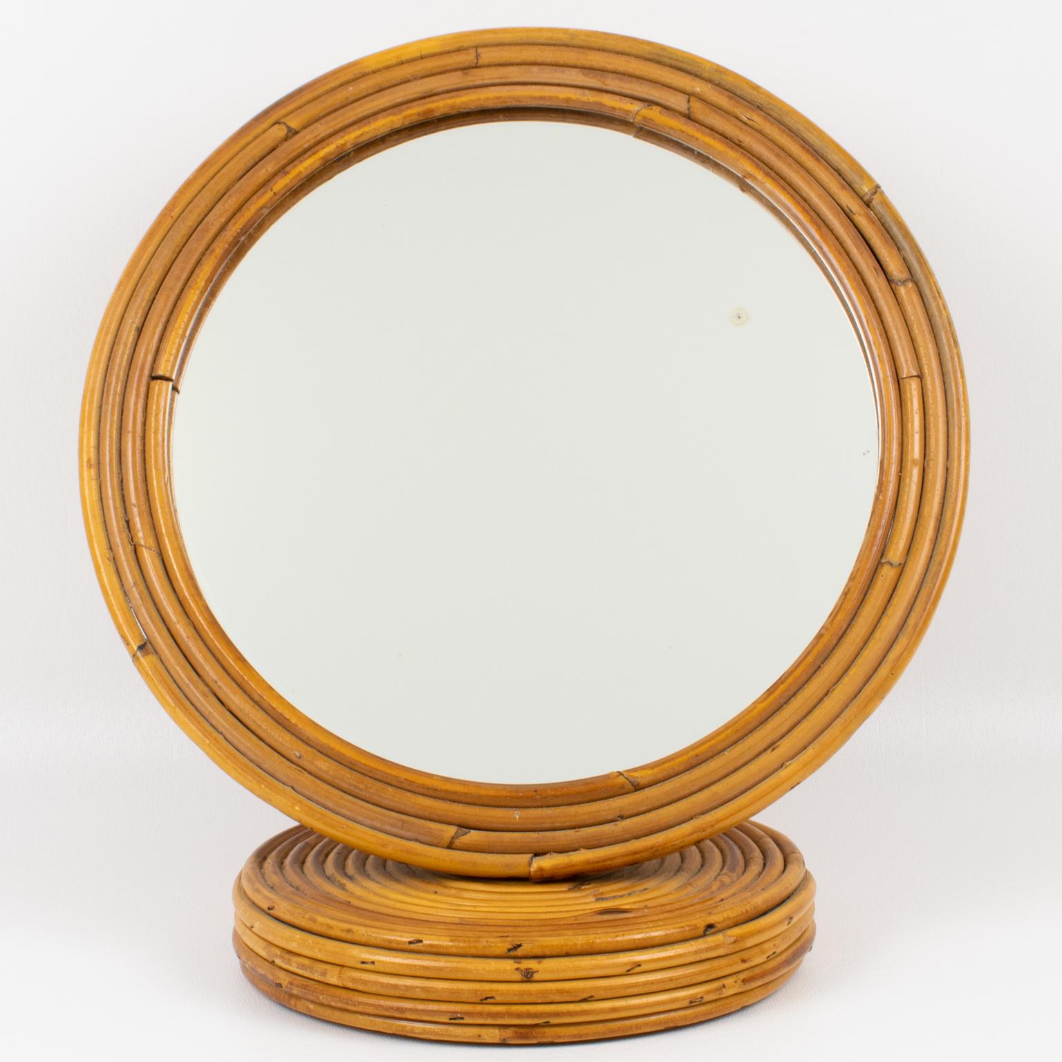 Make a bold statement with this striking Italian table mirror, expertly crafted from rattan or bamboo. The rare piece was crafted in Italy circa 1960. The robust, rounded frame, skillfully woven from pencil reed wicker, exudes sophistication and