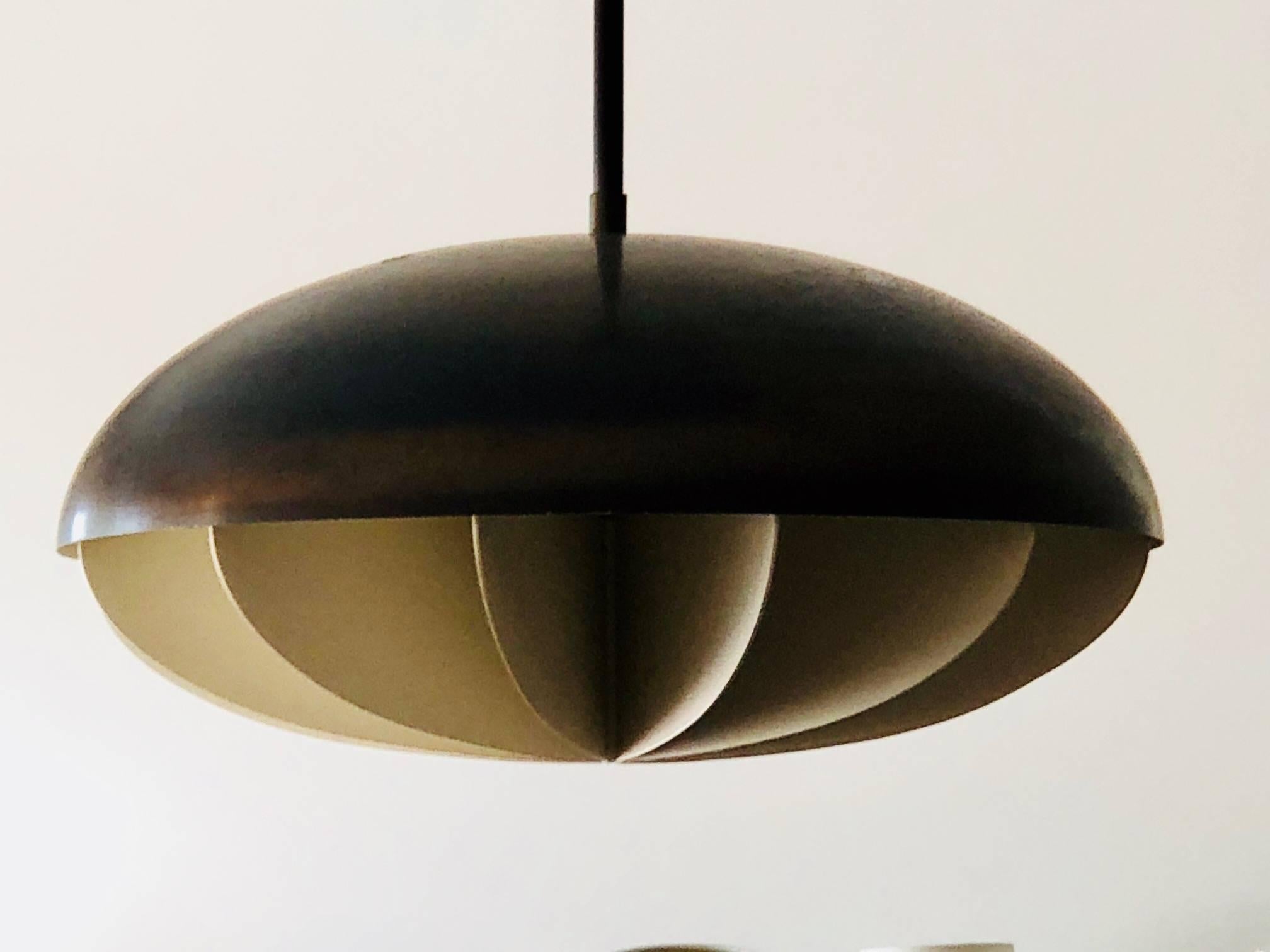 An unusual modernist bronze pendant light. Glass diffuser with white metal paddle fin like shade. Signed Feldman Lighting LA. Total drop is approximate 43