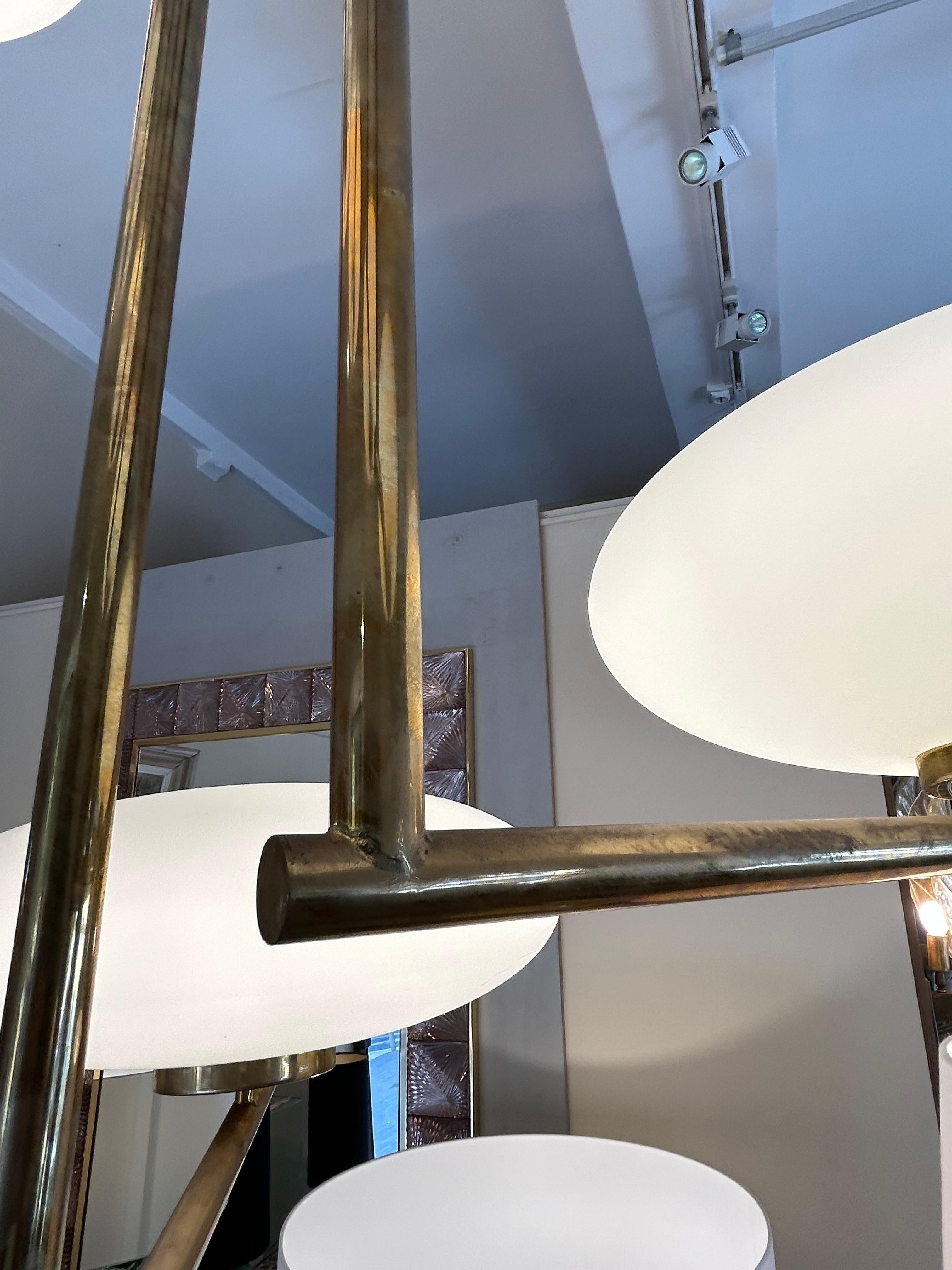 Lampada a sospensione modernista
Metà secolo
Questo apparecchio di illuminazione
è composto da aste in ottone dorato, disposte in modo geometrico ed elegante.
I bracci si estendono orizzontalmente da un punto centrale fissato al soffitto e