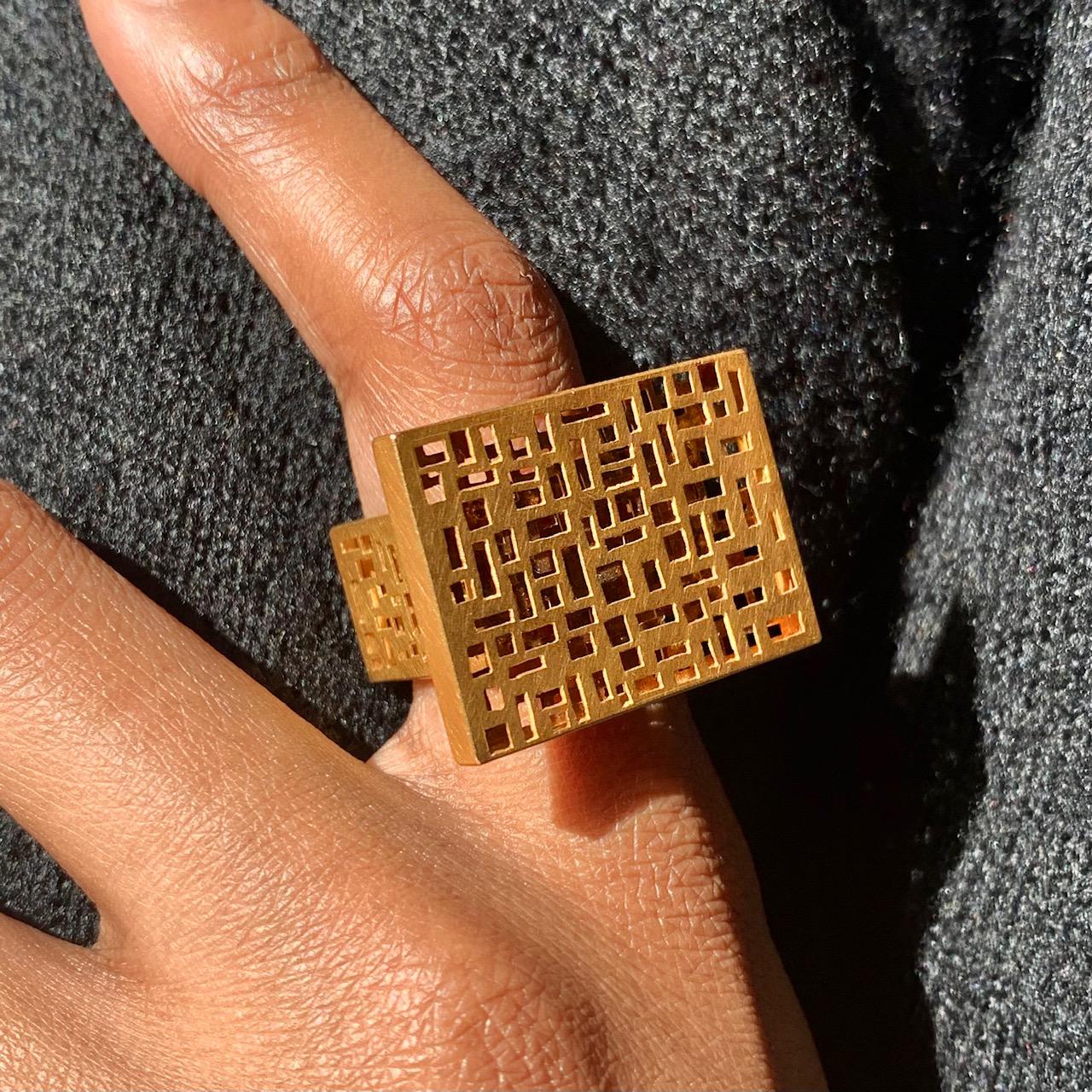 A striking modernist, perforated 8-karat yellow gold ring. The perforations run down both sides of the gold shank. Size 7, stamped. Very comfortable on the finger. Attributed to Michael Becker.

A sculptural statement cocktail ring. The unique