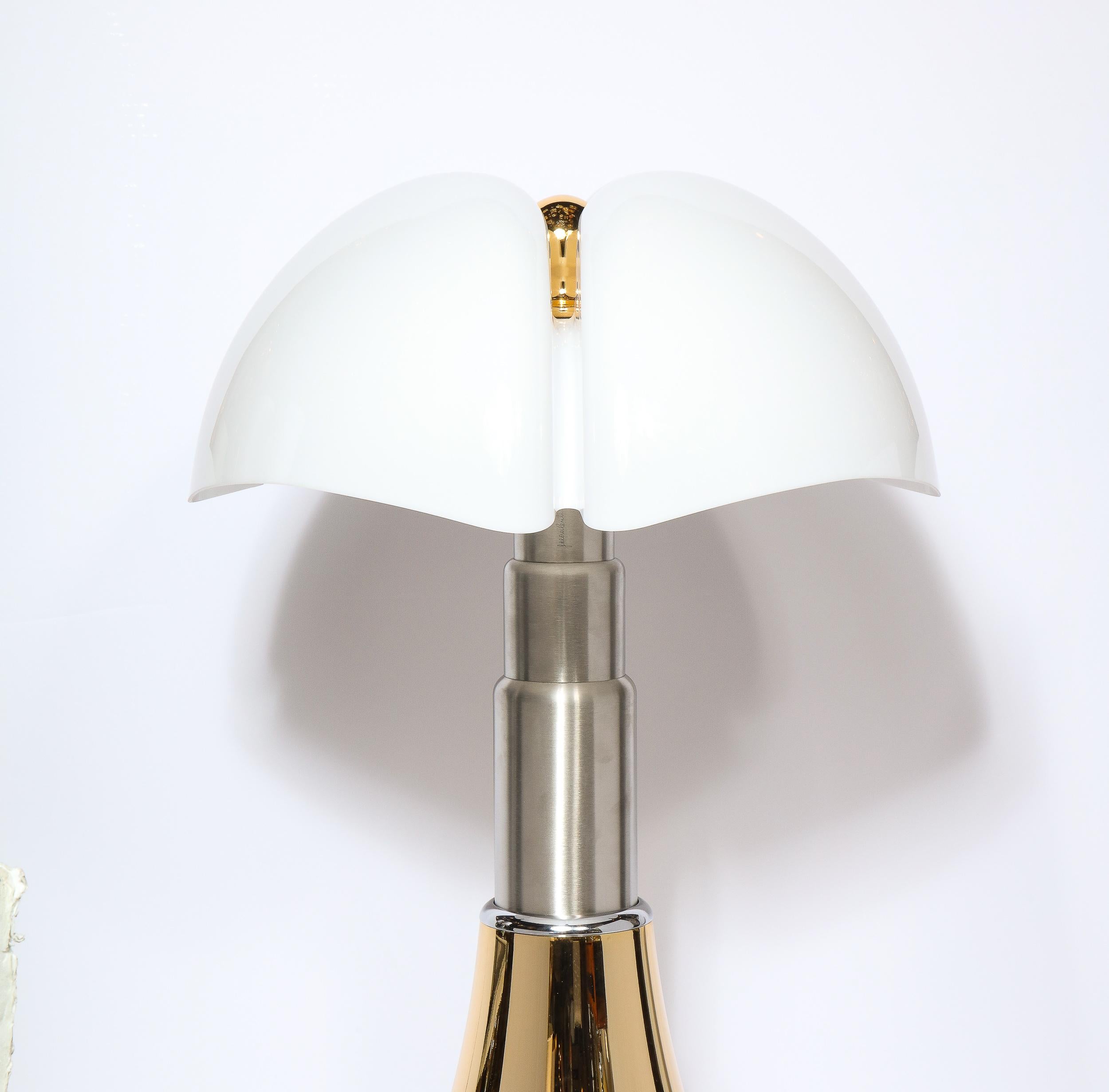 This sophisticated modernist telescoping Pipistrello table lamp was designed by Gae Aulenti for Martinelli Luce. It features a polished brass base that tapers to a tiered skyscraper style brushed aluminum neck on which a sculptural billowing frosted