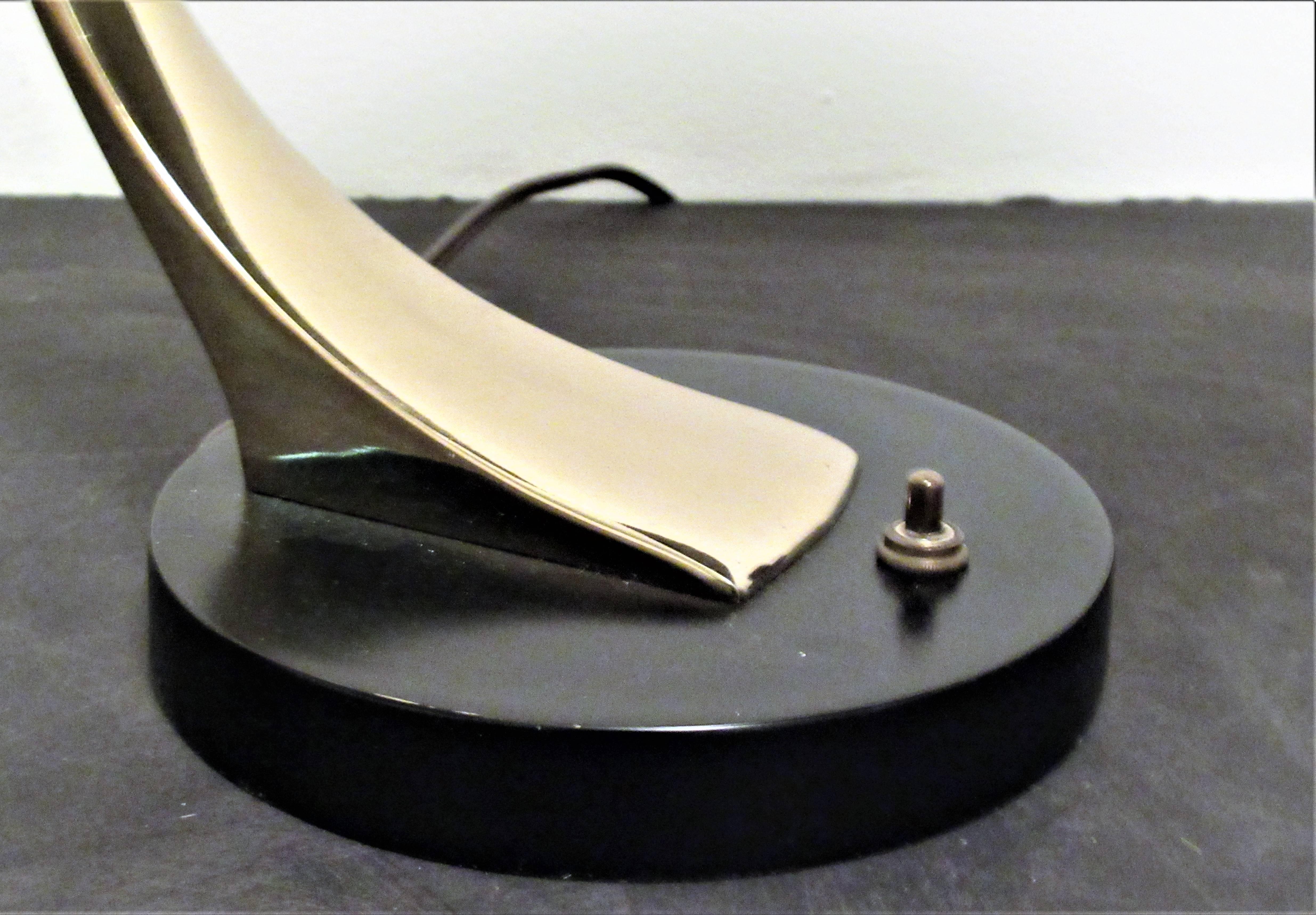 Modernist tabletop arc lamp by Laurel with pivoting adjustable position saucer shaped shade and curved armature in great all original brass and black enamel finish. Signed with paper labels inside shade and socket, circa 1950-1960.