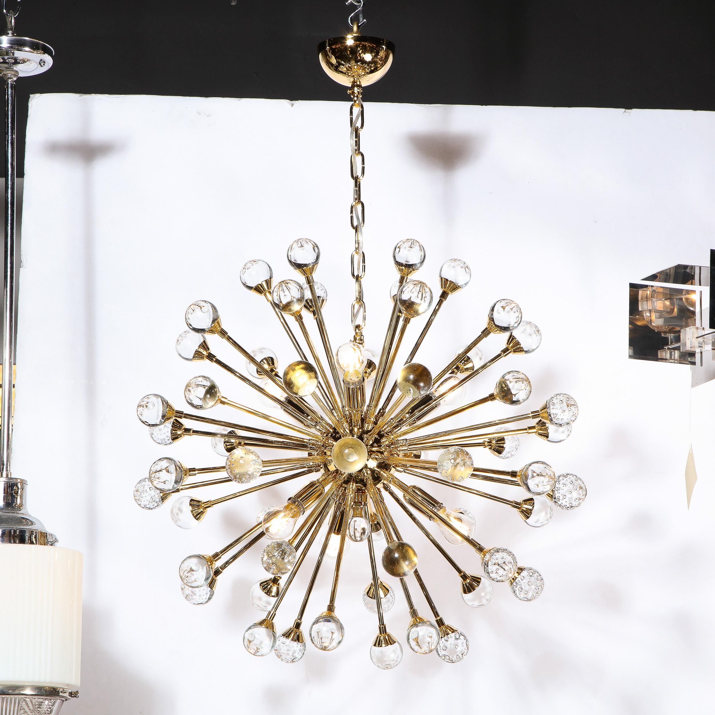 Ce lustre sputnik moderniste, étonnant et graphique, a été réalisé à Murano, en Italie, l'île au large de Venise, réputée depuis des siècles pour sa production de verre de qualité supérieure. Il présente un corps sphérique en laiton poli lustré avec