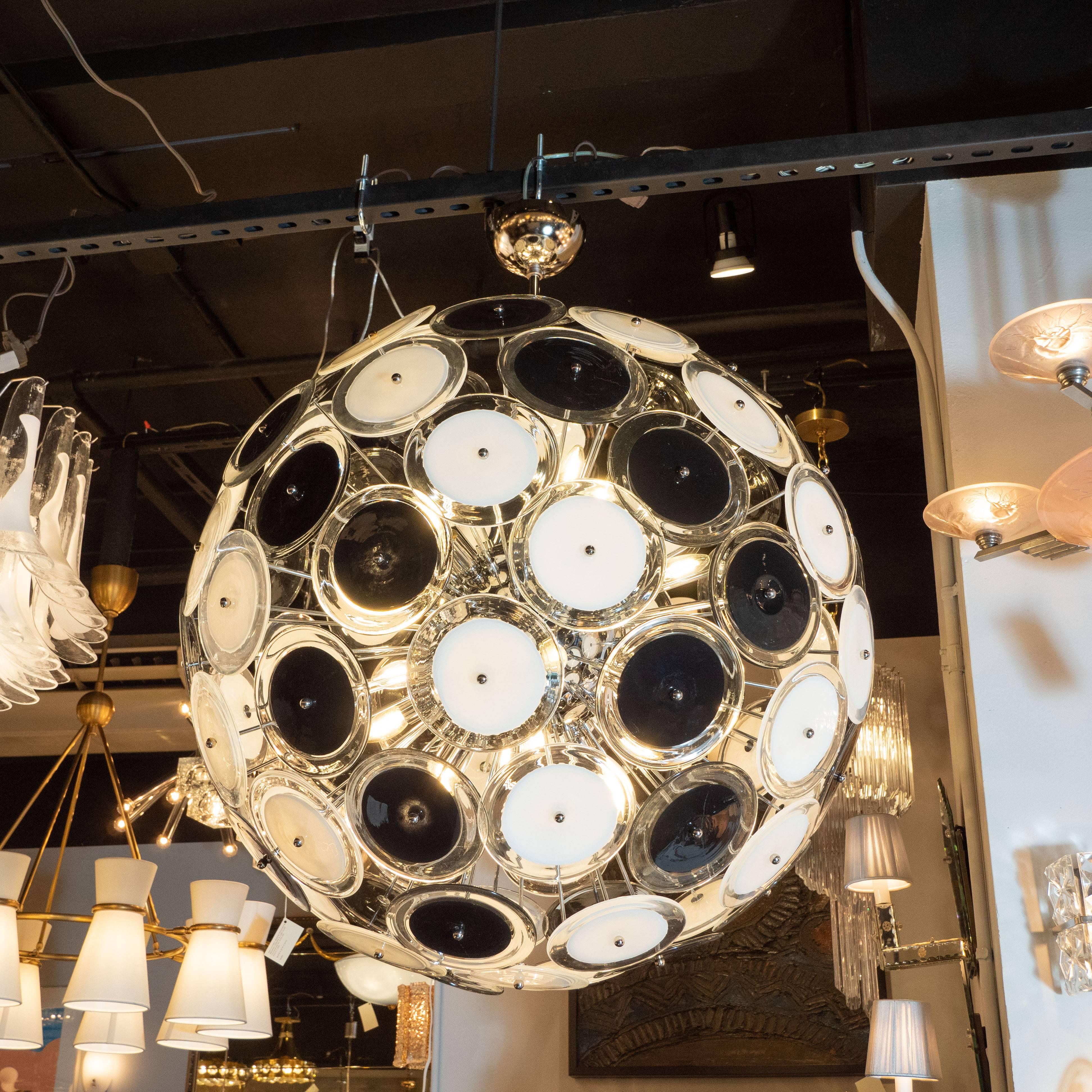 Questo splendido lampadario modernista, realizzato alla maniera di Vistosi, è stato realizzato a Murano, in Italia - l'isola al largo della costa di Venezia rinomata da secoli per la sua superlativa produzione di vetro. Il lampadario presenta