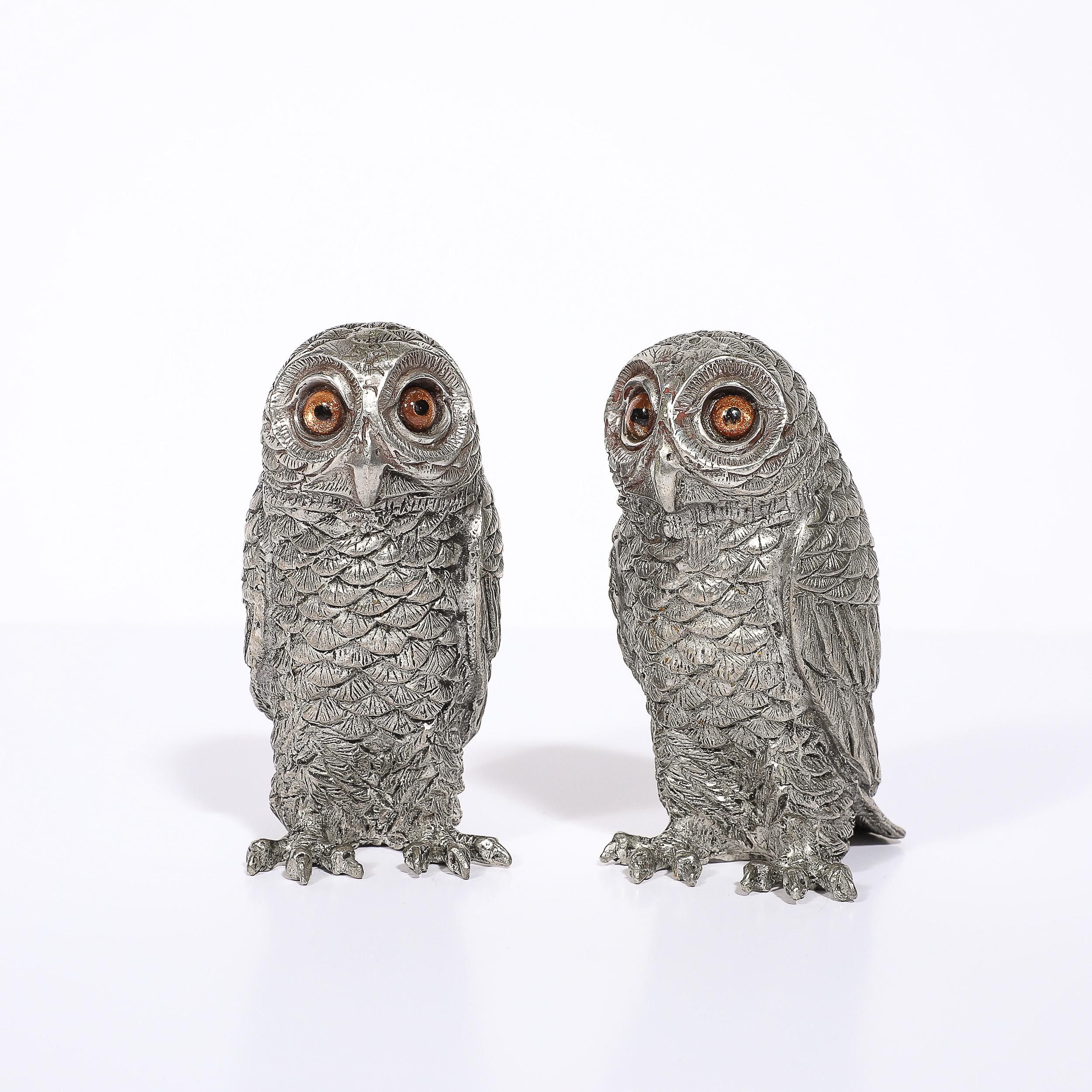These distinct and playful Modernist Polished Pewter and Amber Glass Owl Salt and Pepper Shakers originate from the United States during the latter half of the 20th Century. Formed in a lovely polished pewter depicting ample detailing of the owls