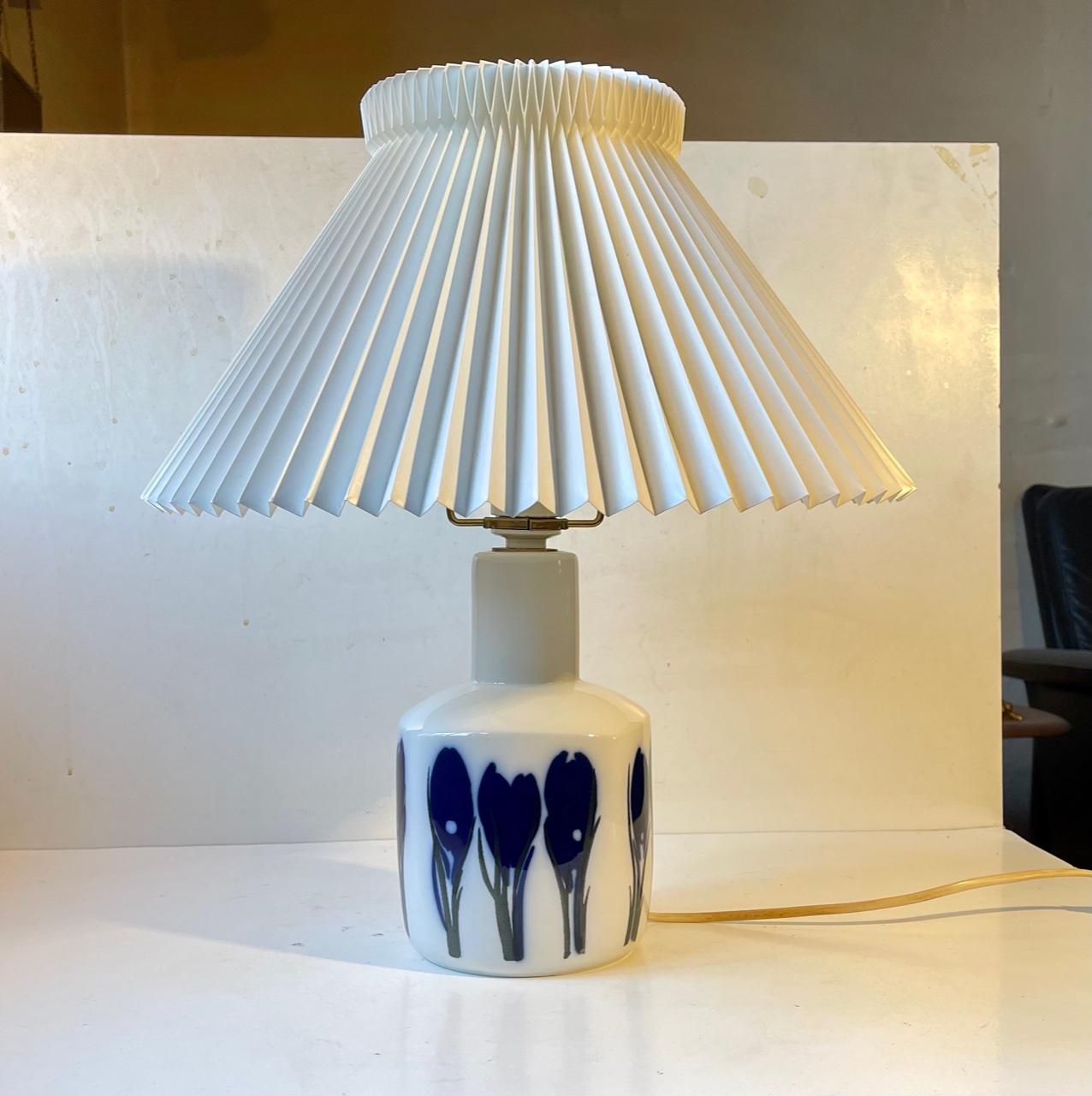 White glazed porcelain table light with an modenist depictions of tulips in blue and black glazes. Designed in-house at Bing & Grondahl in Denmark during the 1960s. This one dates from the 70s. The shade is a model shade and is not included.