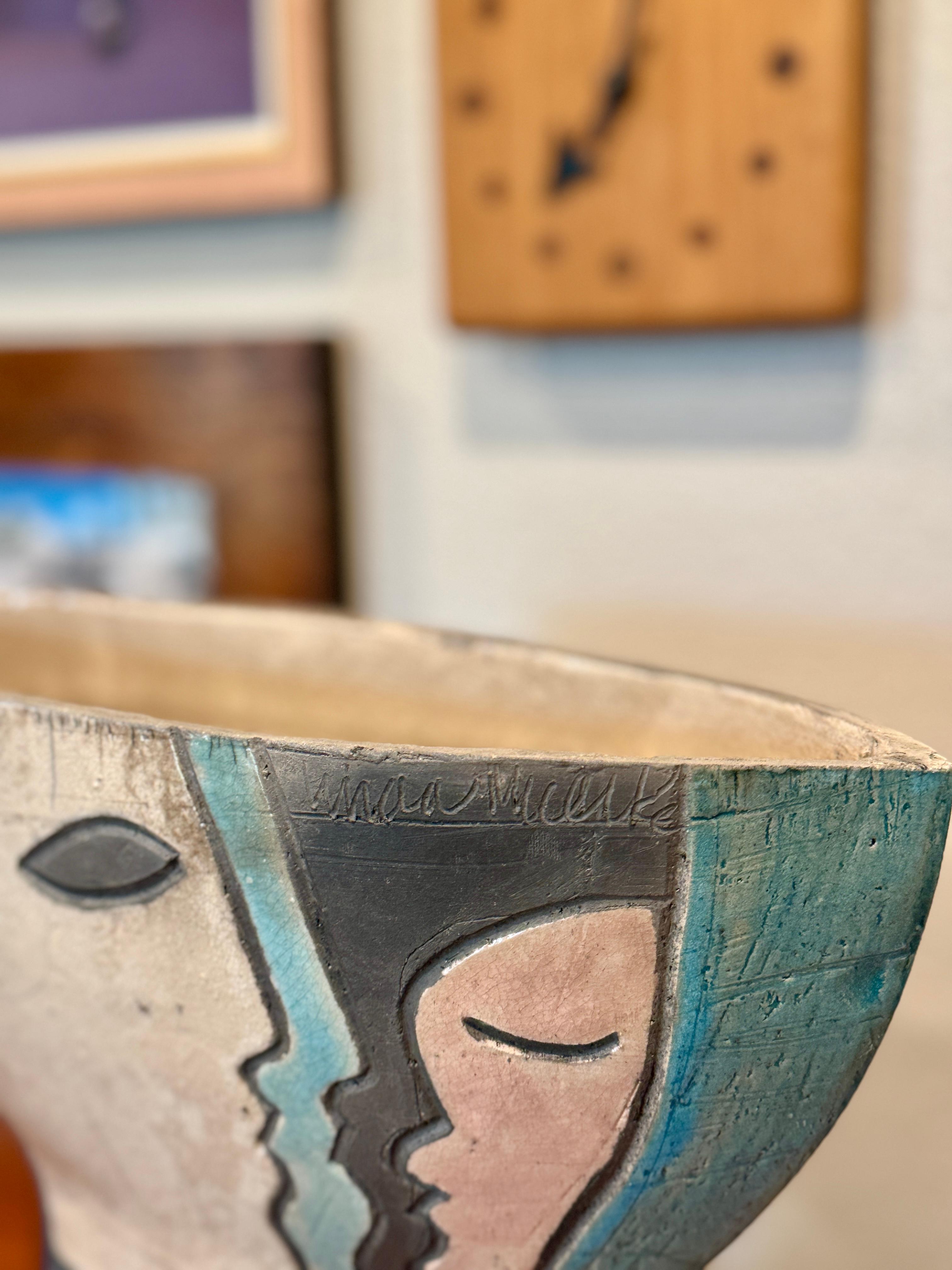 Modernist Raku Pottery ceramic vase with abstract faces, circa 1960s. Signed by the artist Linda Mielke. In very good condition with no chips or cracks. 

12.5” H x 13” W x 4” D
