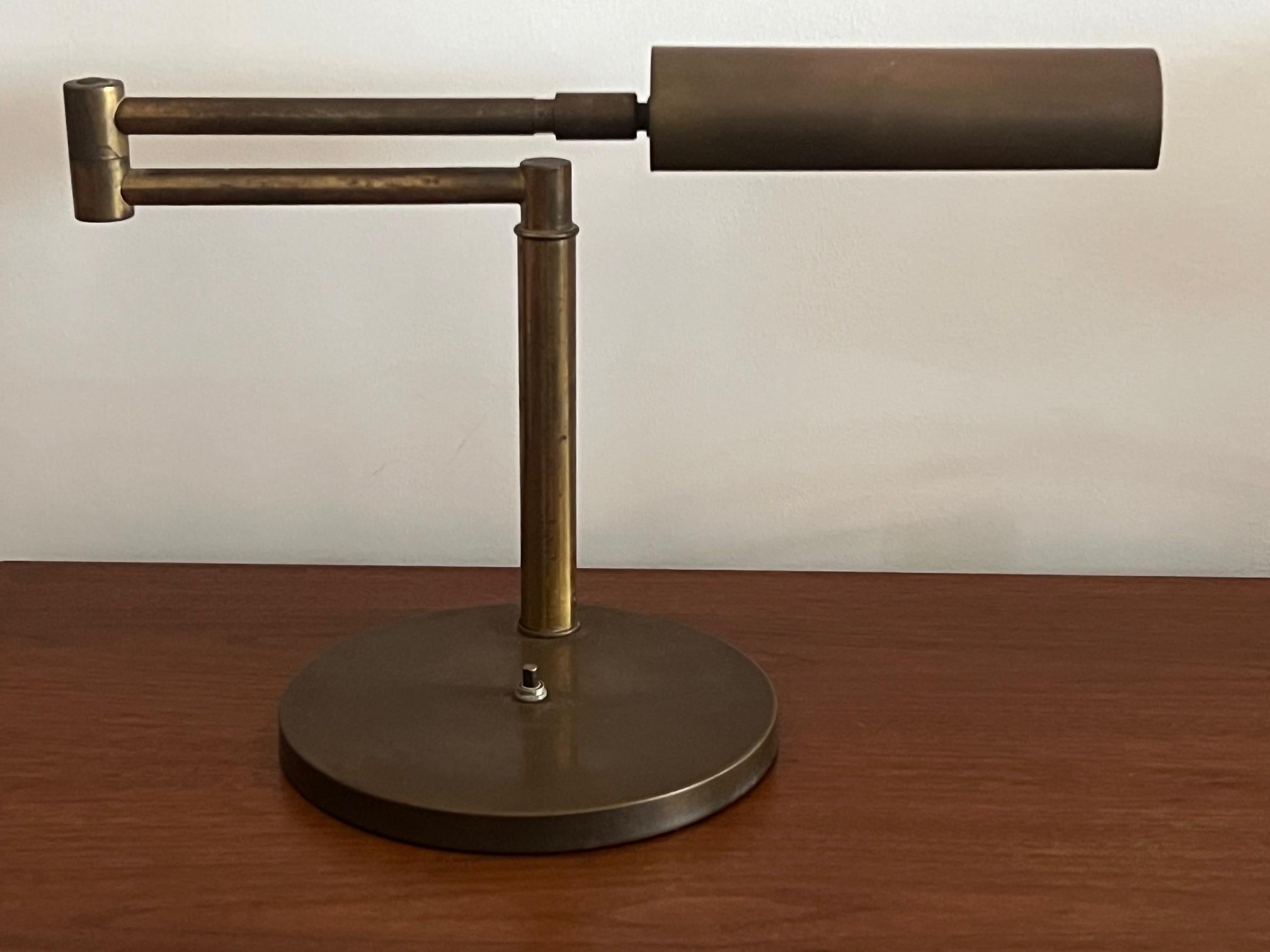 A classic, modernist, reading lamp by Nessen. Patinated brass, pivoting, rotating shade.