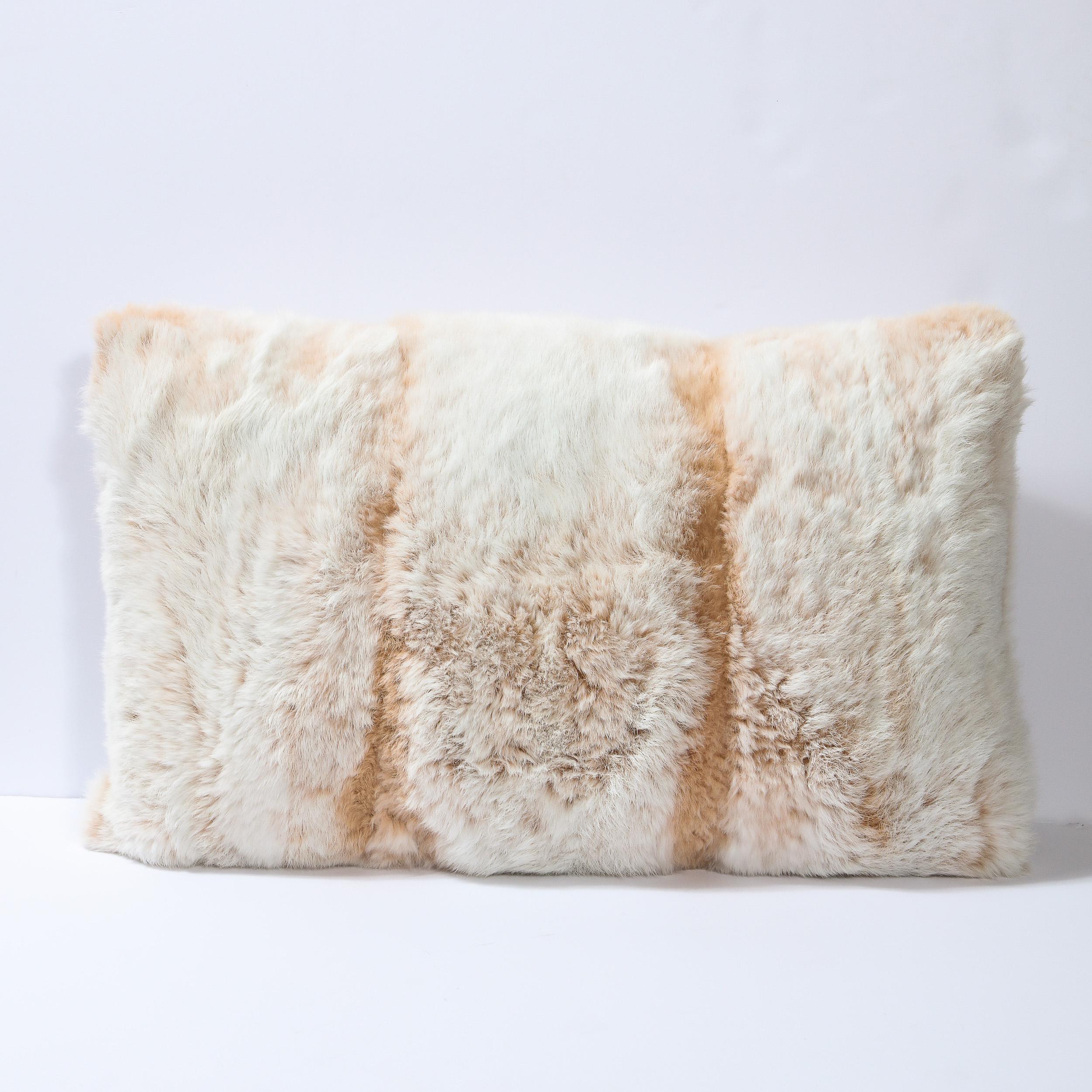 This elegant modernist pillow was realized in the United States. It features an incredibly soft and lush rabbit fur front with two muted orange bands against an off white background. The back is a soft gray cotton fabric, and the pillow features a