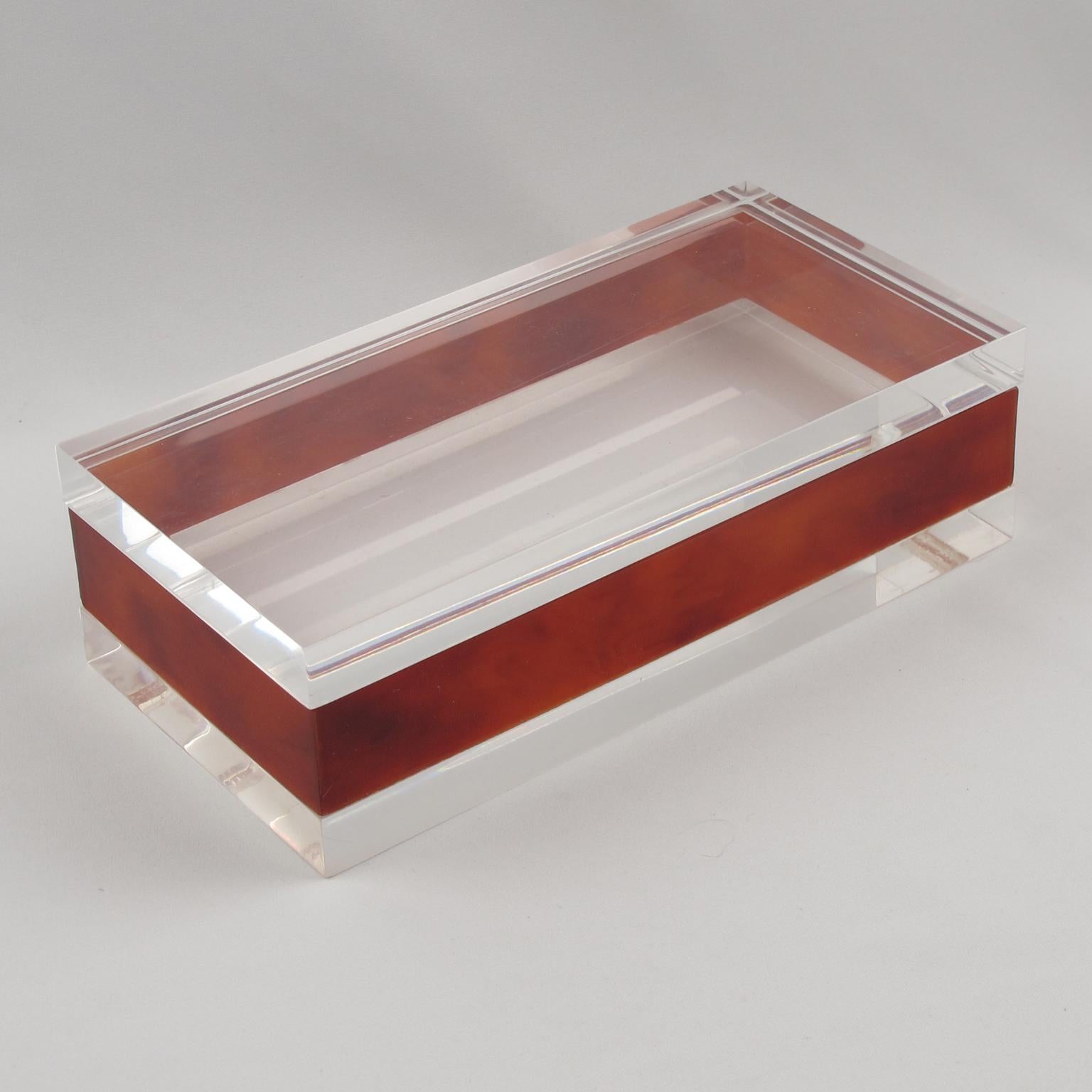 Questa splendida scatola modernista con coperchio in lucite e acrilico è stata realizzata in Francia intorno al 1970. Il suo design ricorda il lavoro della Maison Mercier Freres. Il pezzo vanta colori di marmo trasparenti e ambra rossa con una forma