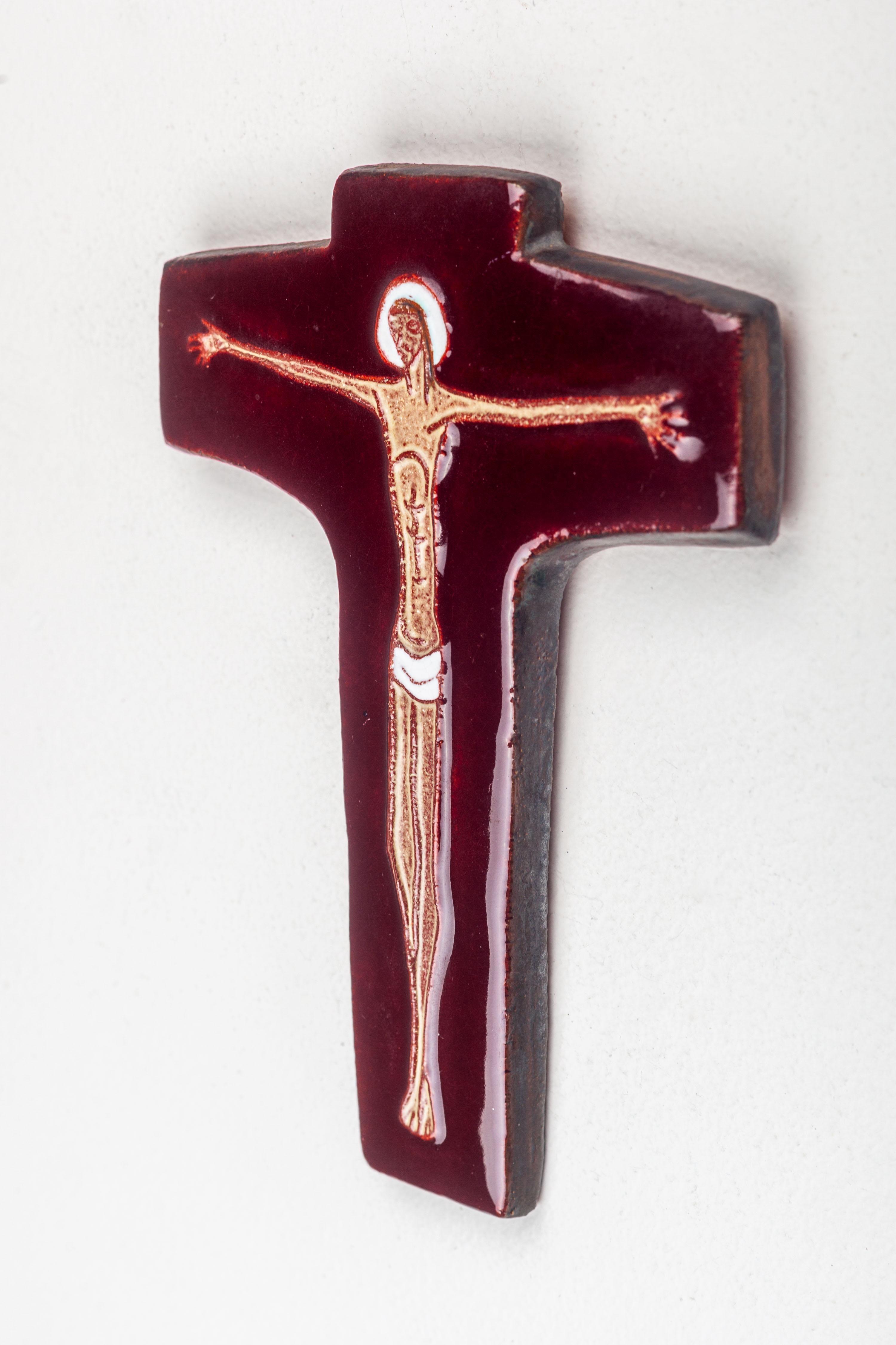 Modernistisches Kruzifix, hergestellt in Europa von Studio Pottery Künstler. Das tief rotbraune, glänzende Kreuz kontrastiert mit dem matten, langgestreckten, schwebenden Christusrelief, das in typisch modernistischer Manier gestaltet ist. Die