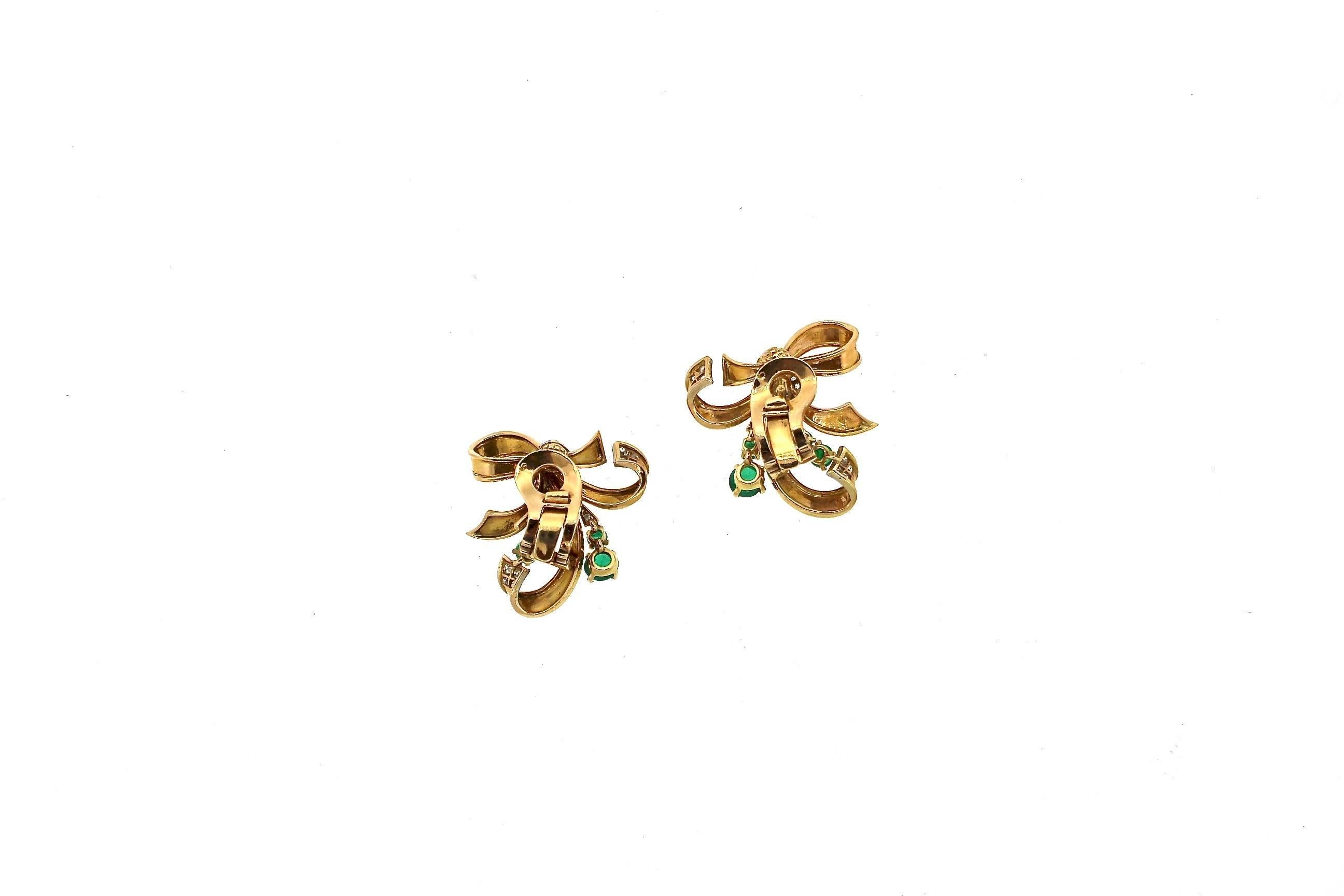 A feminine stylized ribbon earrings accented by cabochon emeralds and diamonds from the 1940s. This fun pair of earrings is quintessential Retro style, with rounded ribbon shapes and accents of bright color. The earrings have the French gold